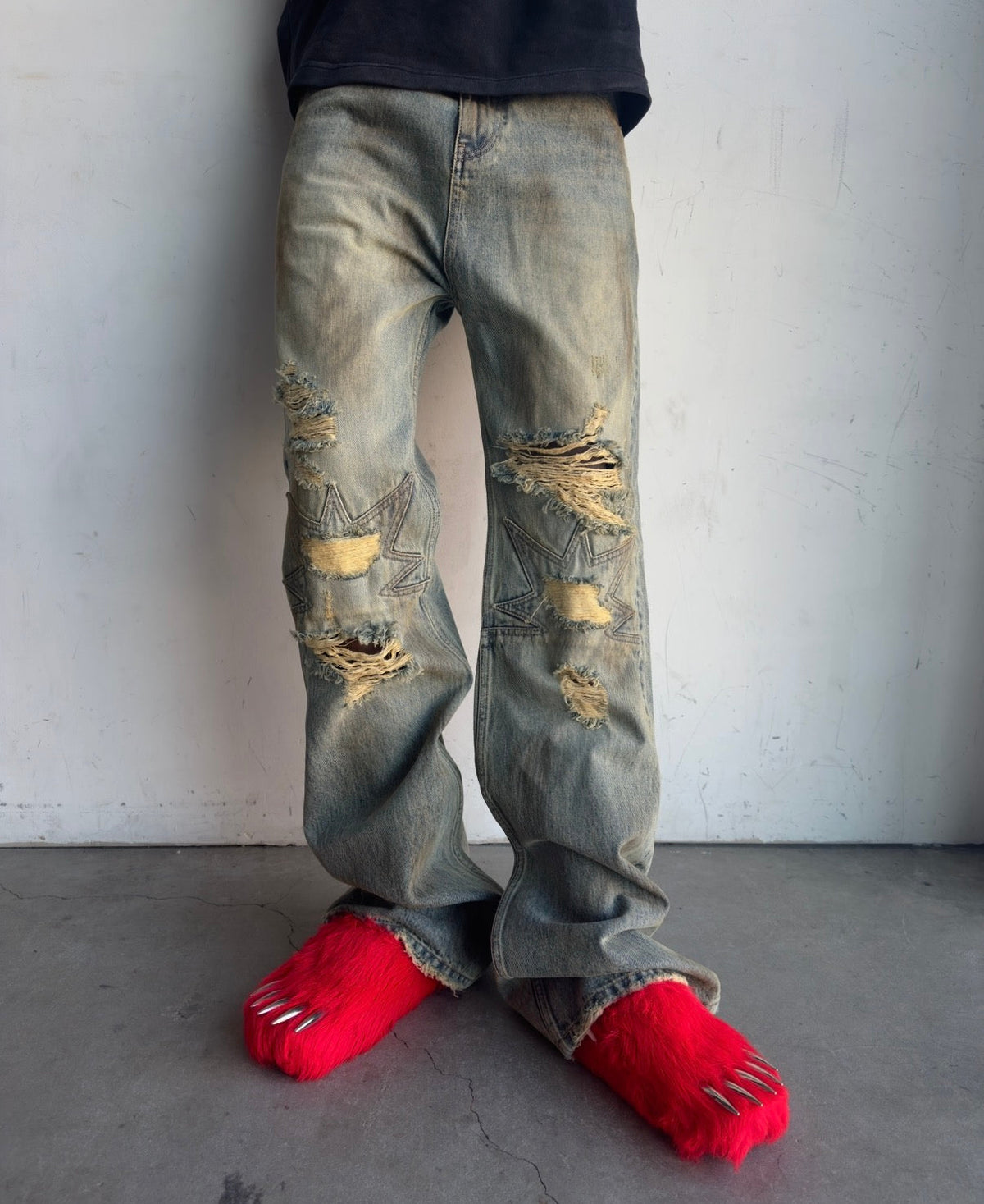 Red fur bear claw mules under cuffed denim jeans, open toe with claw accents
