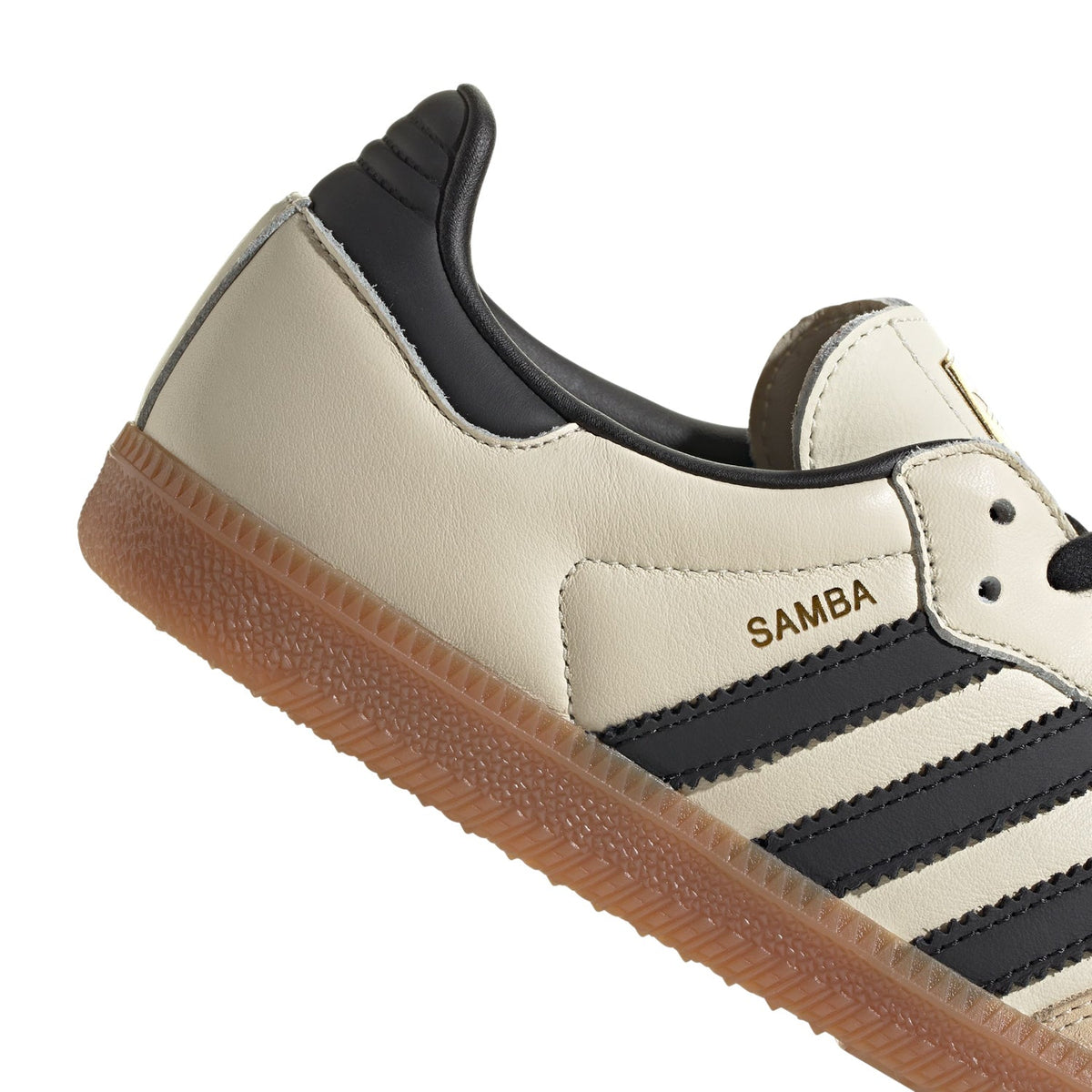 Adidas Samba OG women's sneaker close-up: 'SAMBA' label, black collar trim, gum outsole edge.