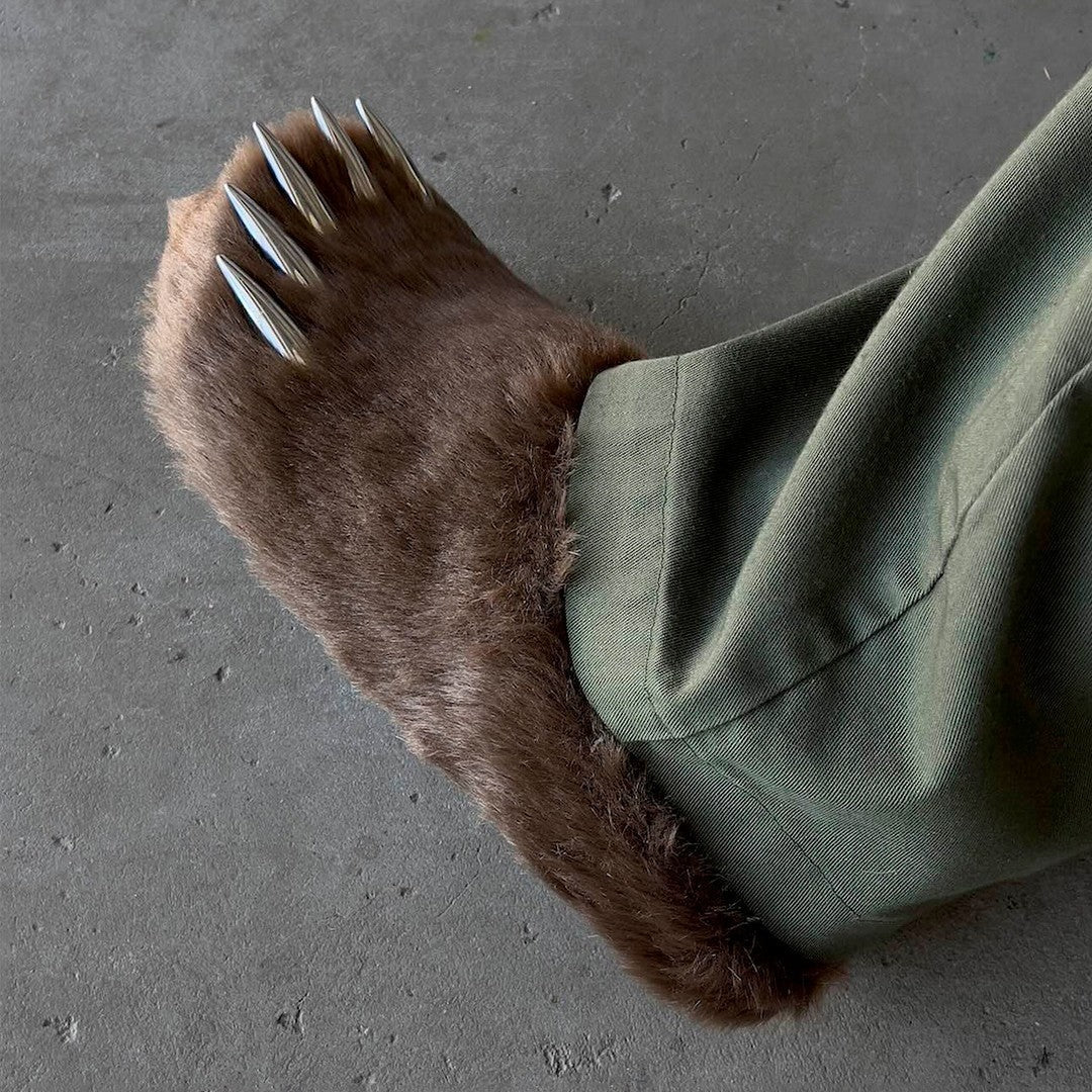 Brown faux-fur bear claw mule with metal spikes, worn with green pants