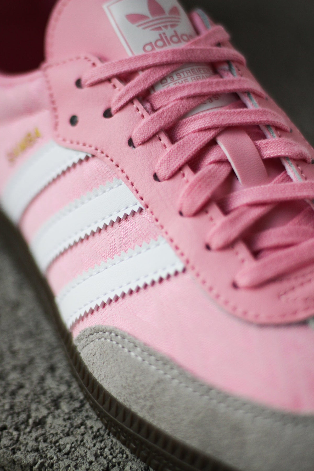 Kids' light pink adidas Samba sneaker close-up with pink laces and white stripe accents