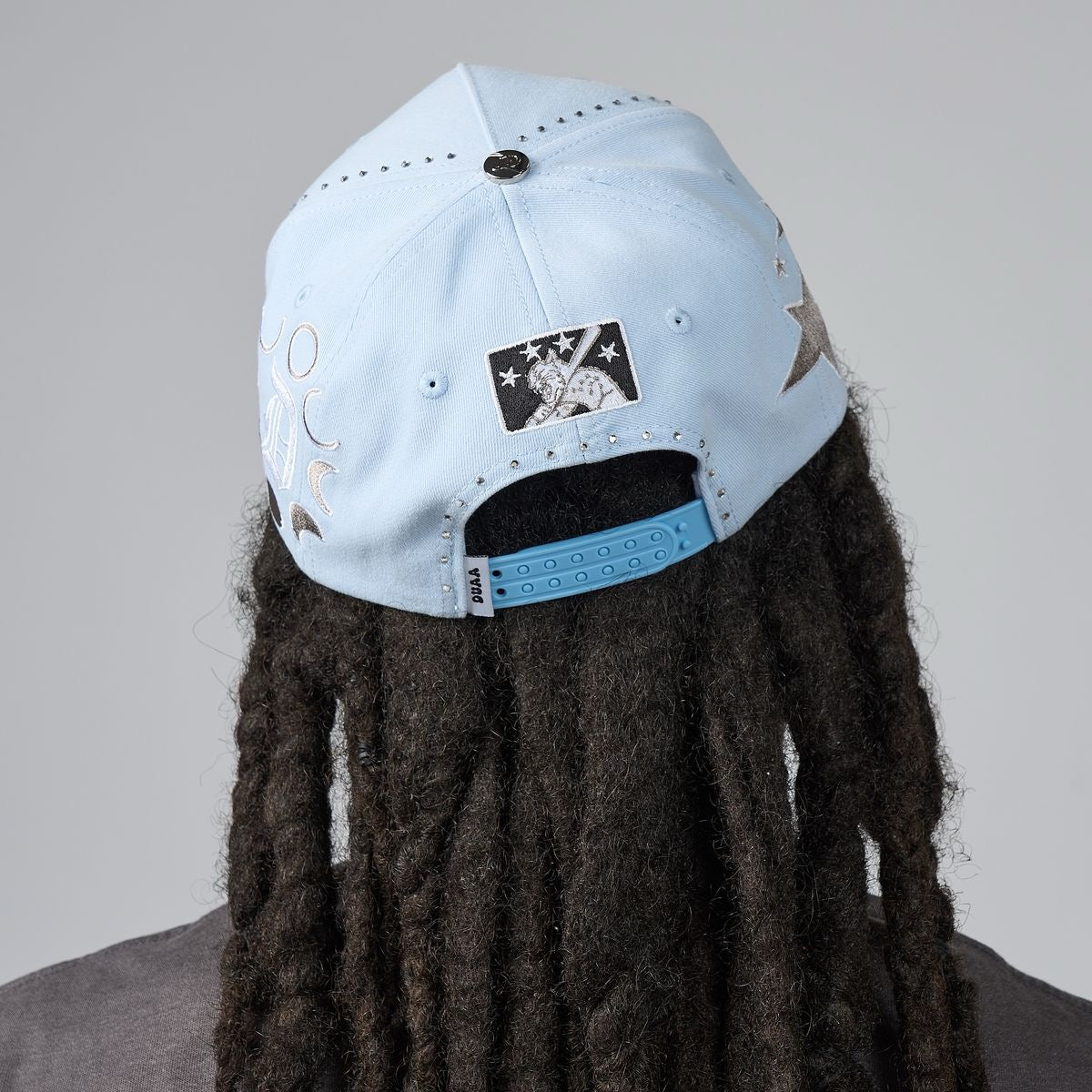 Light blue men's baseball cap back view with moon graphics and star patch