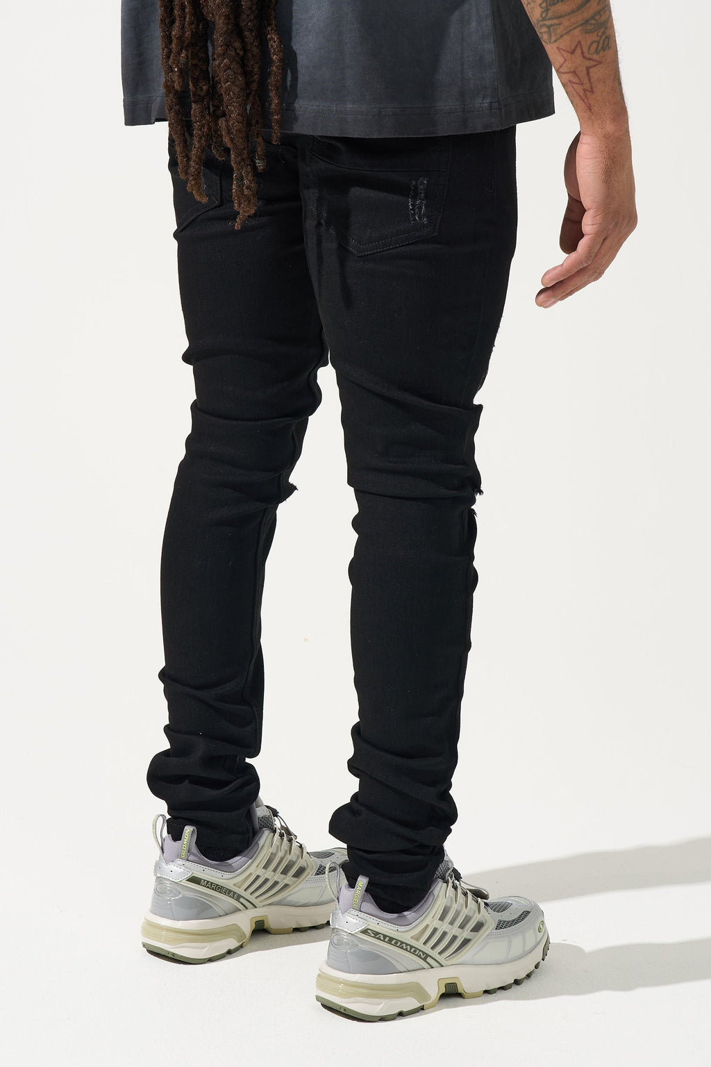 Men's black jeans with heavy distressing on knees and straight-to-tapered cut