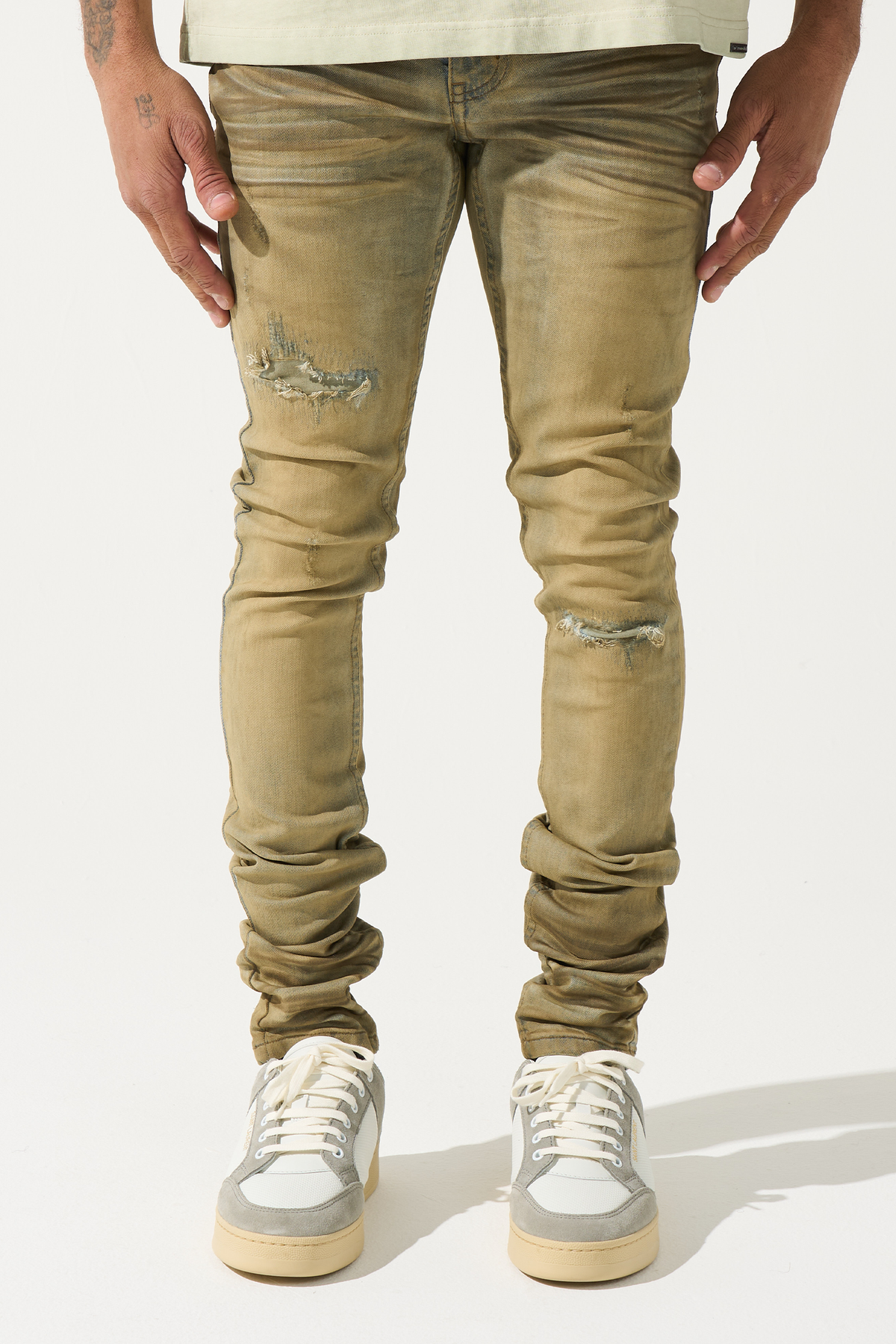 Men's distressed skinny jeans in muted olive with knee rips and stacked seam fades