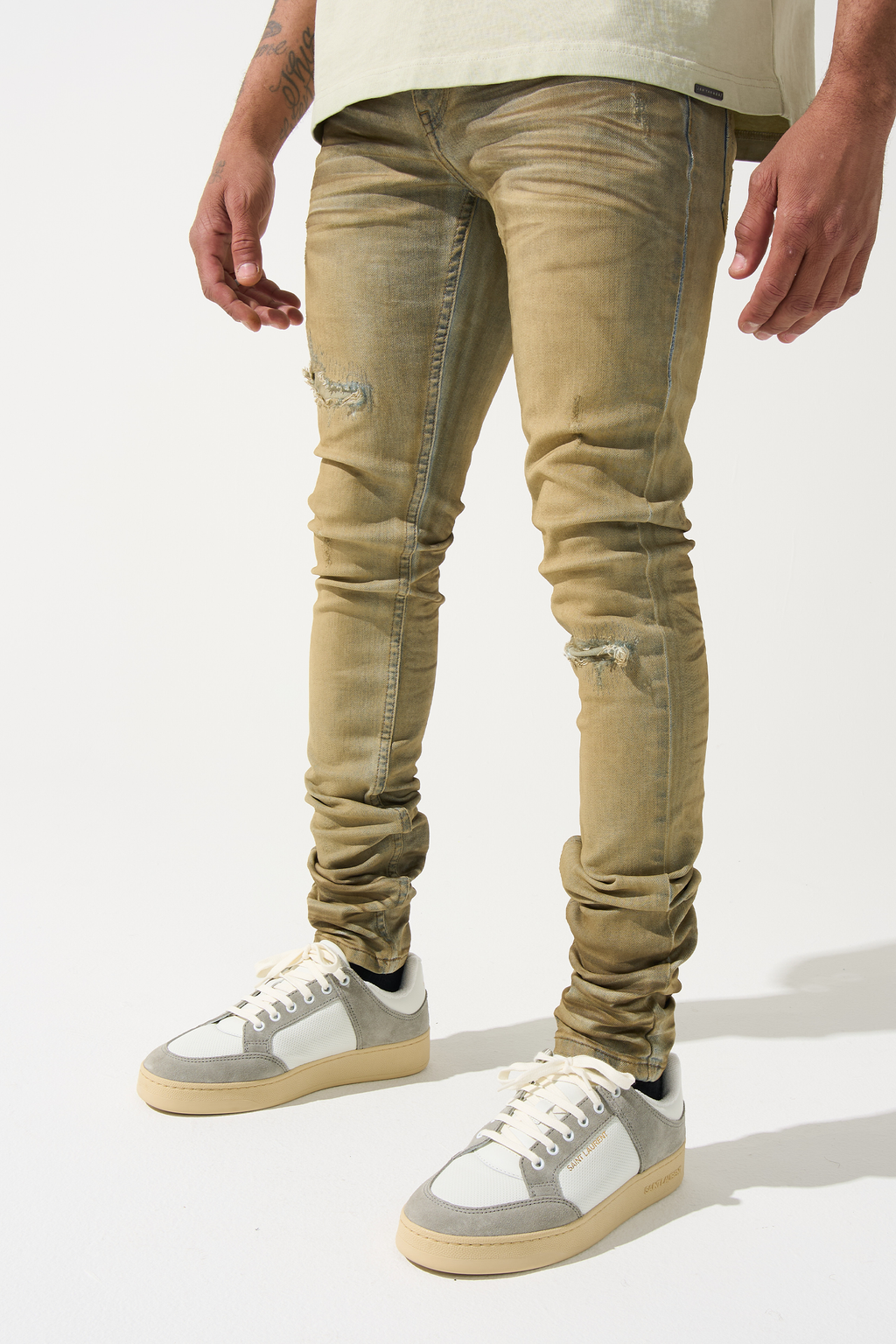 Men's distressed skinny jeans in muted olive with faded wash and ripped knee details
