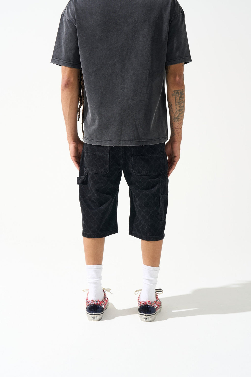 Men's black denim shorts, knee-length with monogram-like wash pattern