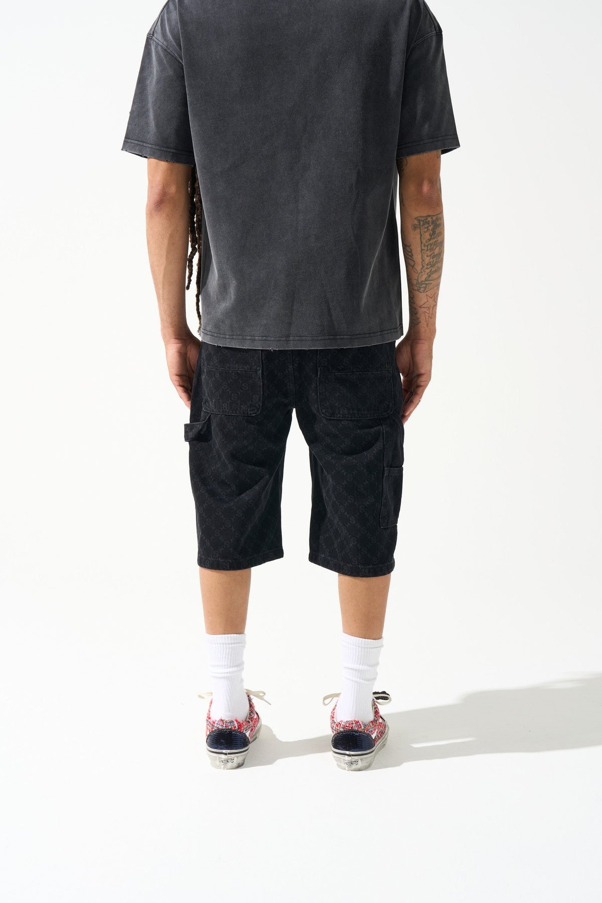Men's black denim shorts, knee-length with monogram-like wash pattern