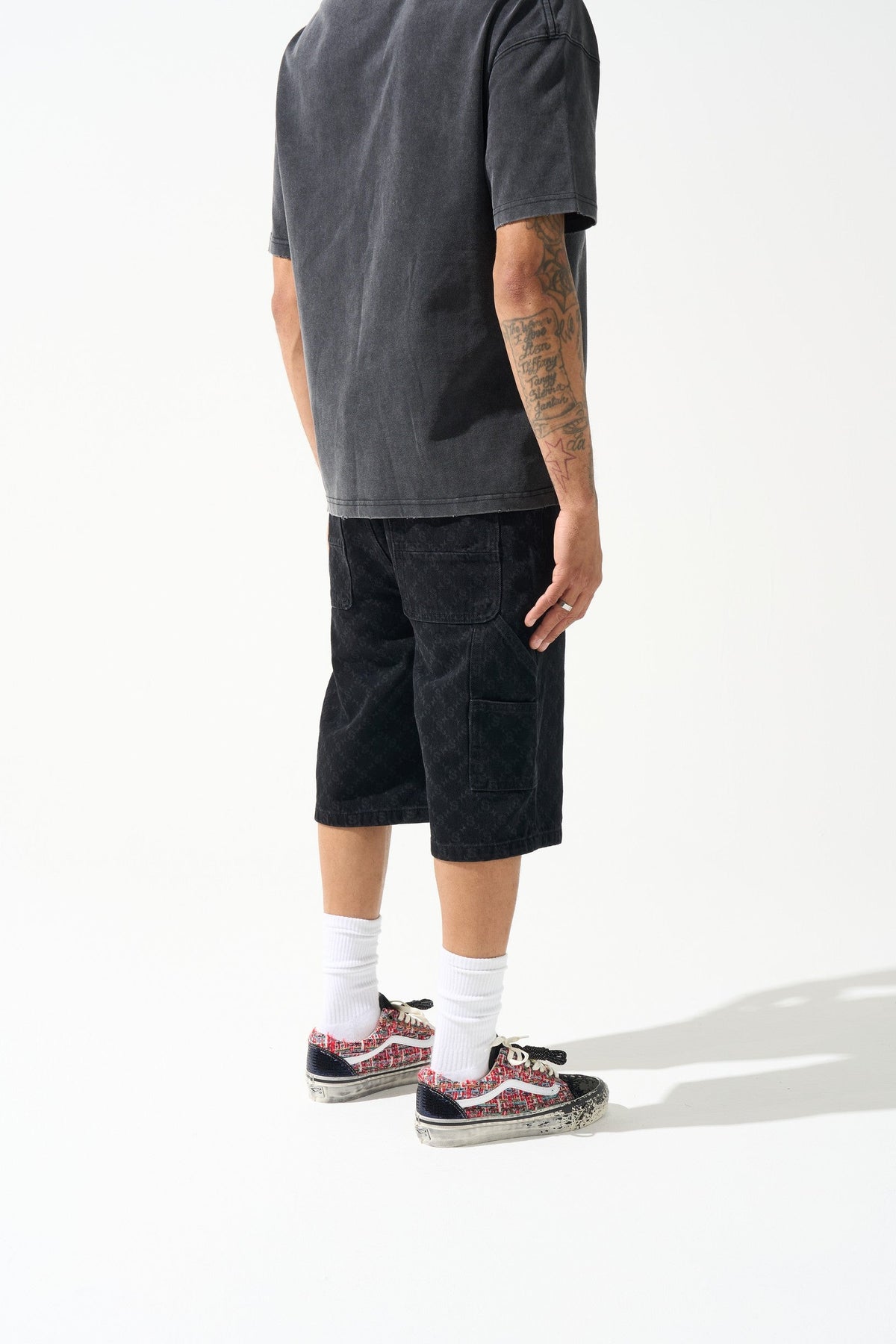Black denim shorts with monogram texture, knee-length hem and side pocket
