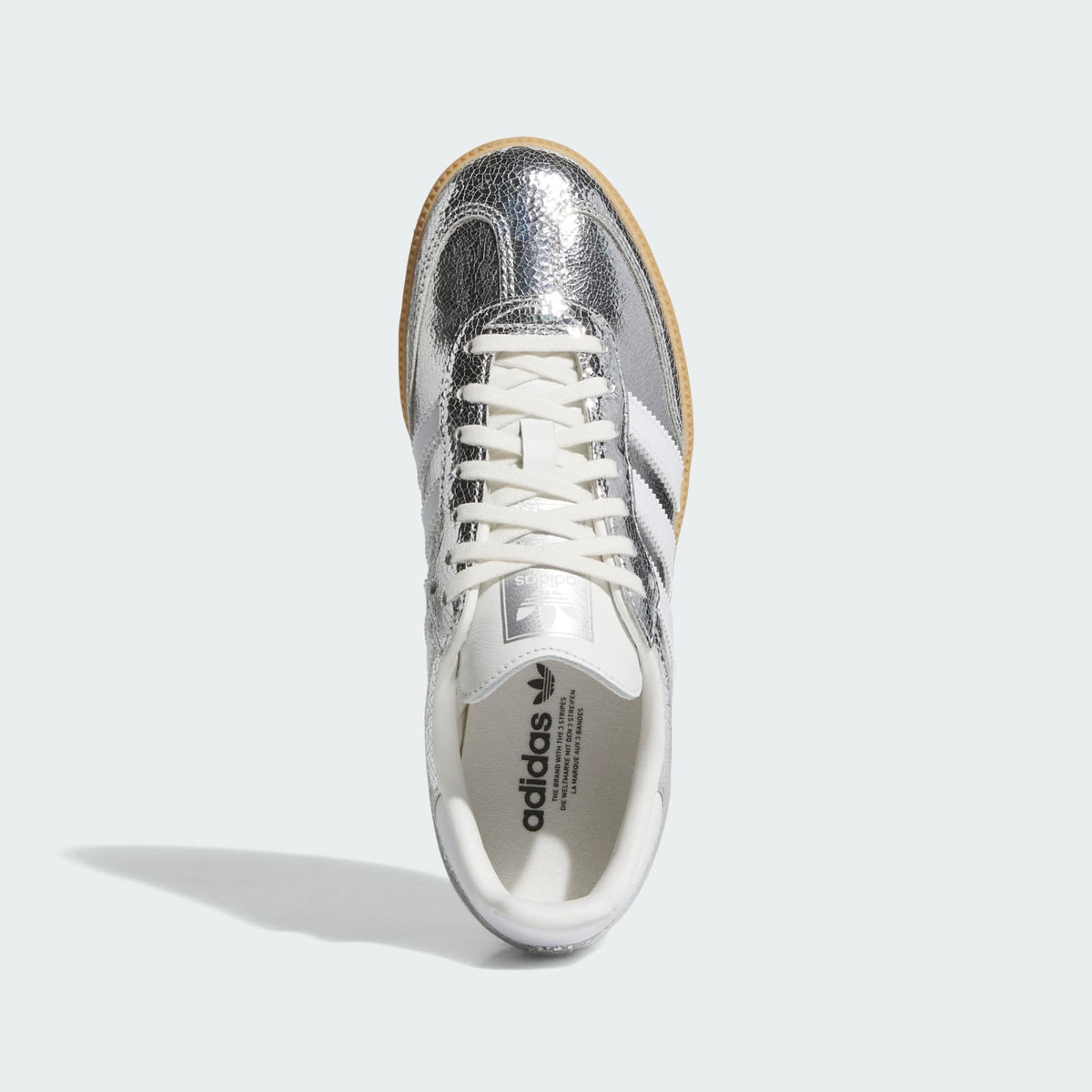 Kids' Samba OG J sneakers toe and lace view; silver metallic upper, white tongue.