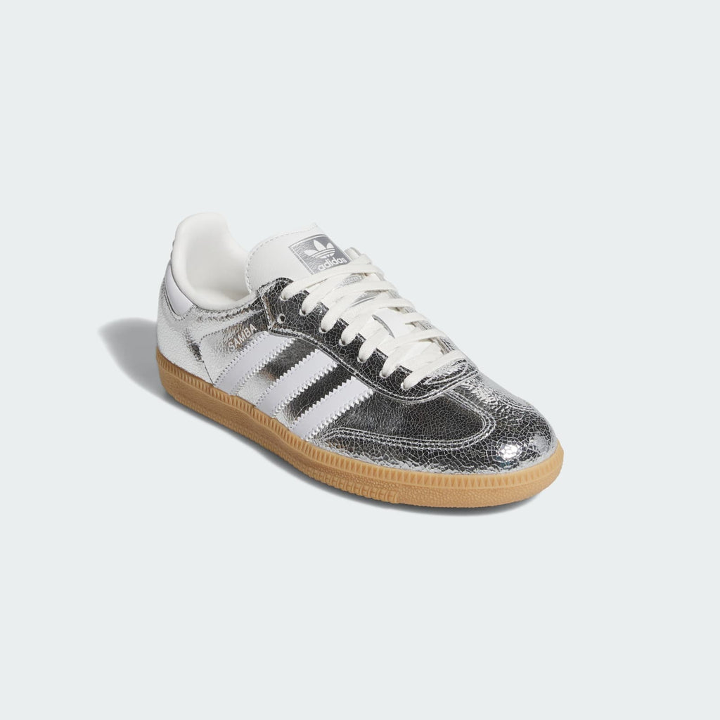 Kids' Samba OG J sneakers side view; silver metallic leather, white stripes, gum sole.