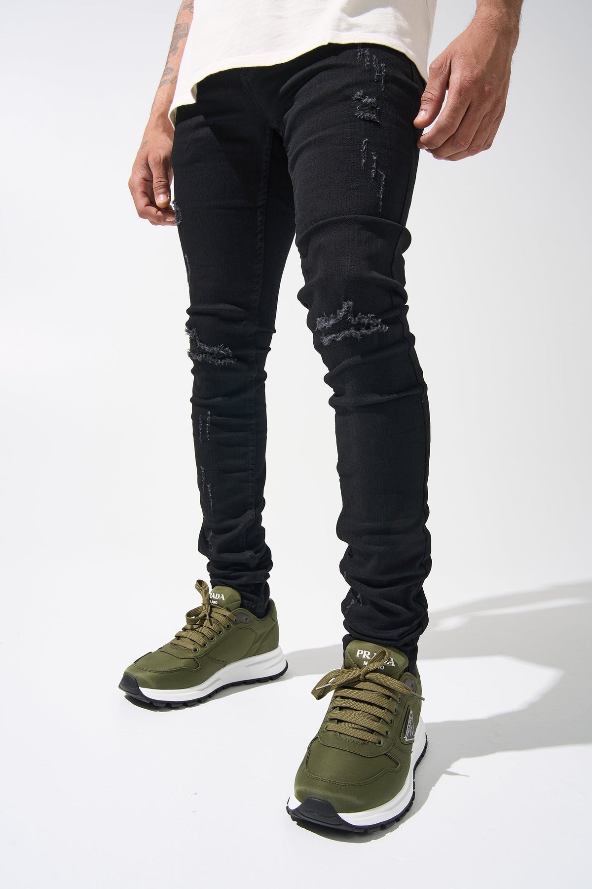 Men's dark denim jeans with ripped knee rips and tapered silhouette