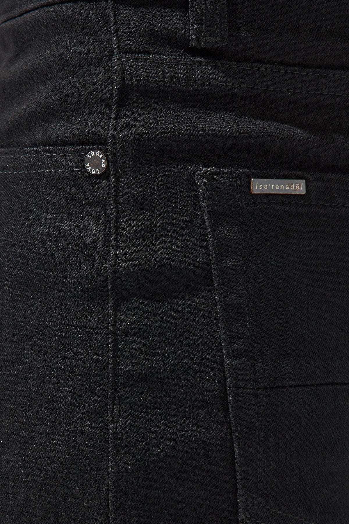 Men's dark jeans close-up: waistband button, belt loops, and stitched pocket