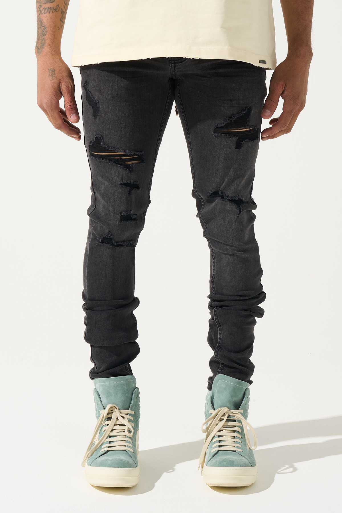 Men's charcoal straight jeans with large knee rips and cuffed distressed look