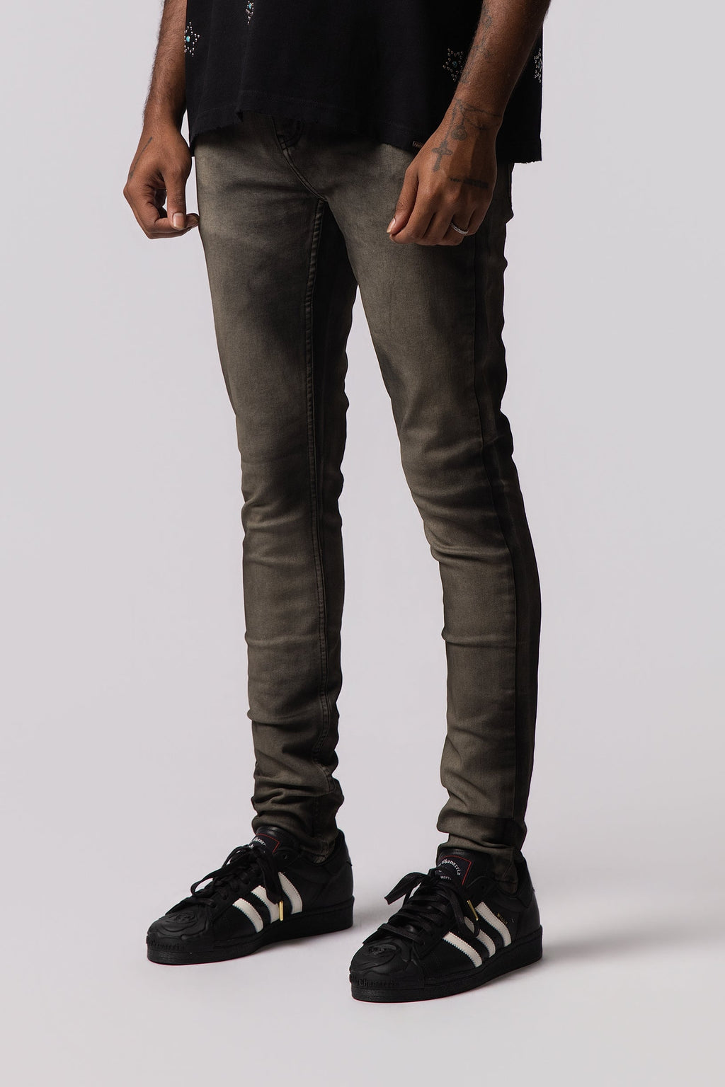 Men's olive-wash jeans, slim tapered legs with stitched seams.