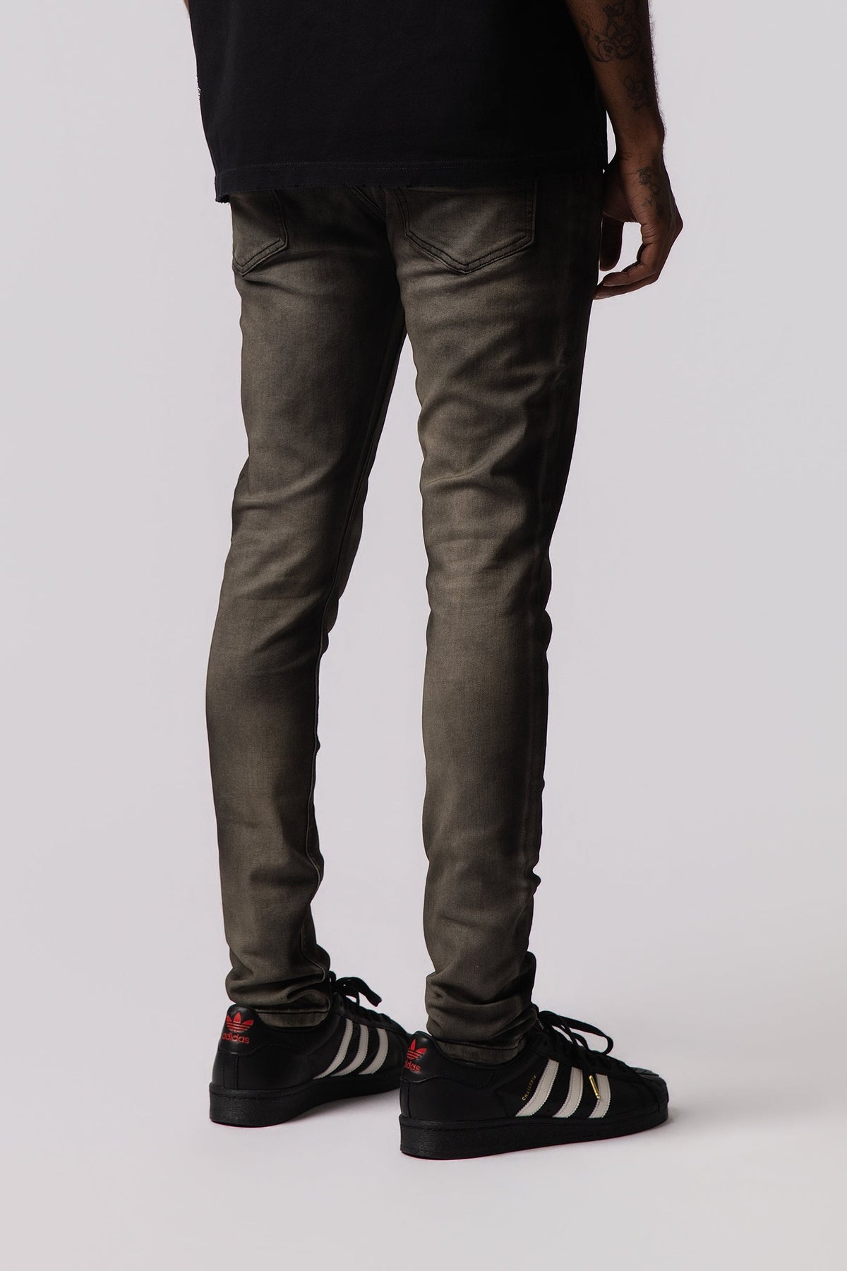 Men's olive-wash jeans, slim fit with cuffed ankle hem and side pockets.
