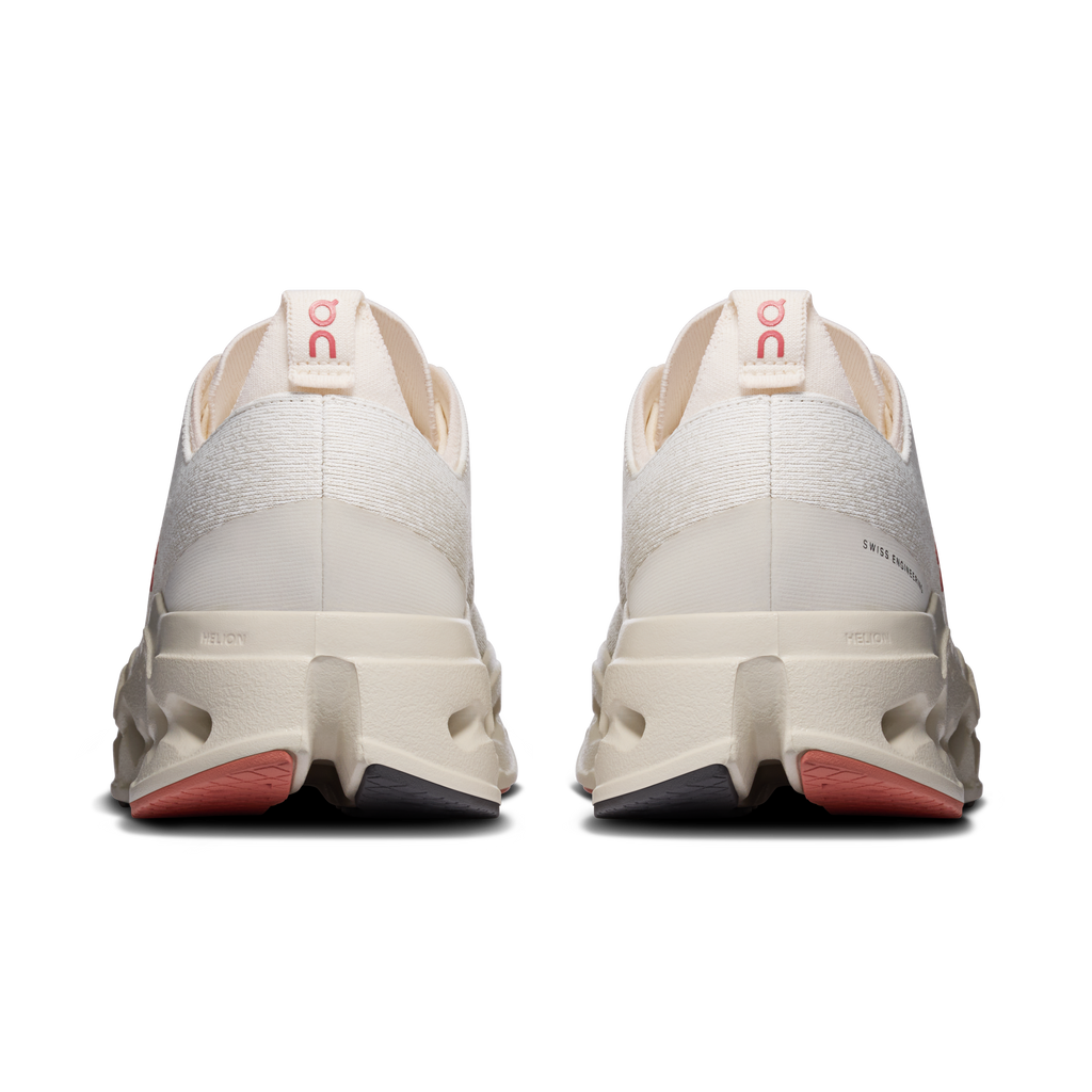 On Cloudsurfer Max heel view, ivory shoes with red logo tab and cushioned rear sole