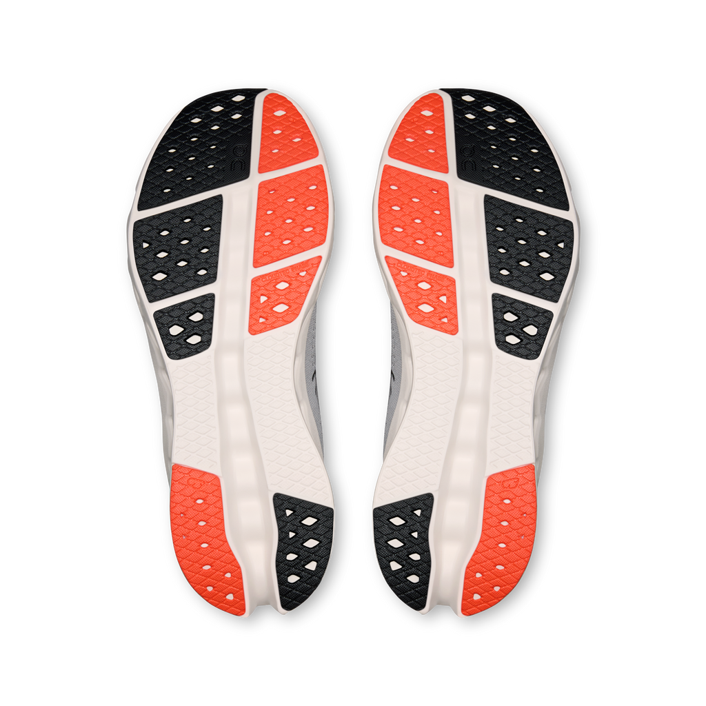 Shoe outsoles showing black tread with orange heel areas and white midsole.