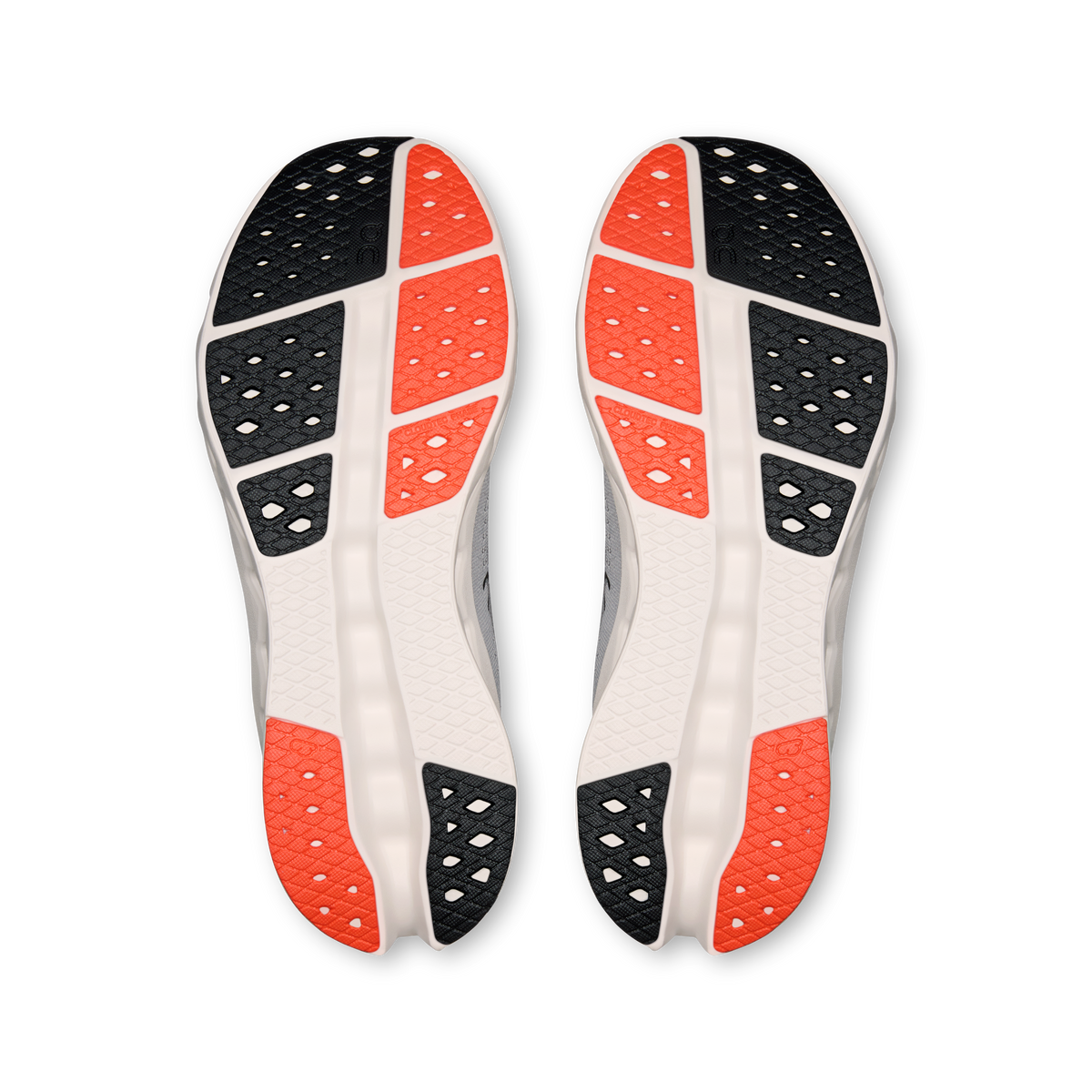 Shoe outsoles showing black tread with orange heel areas and white midsole.