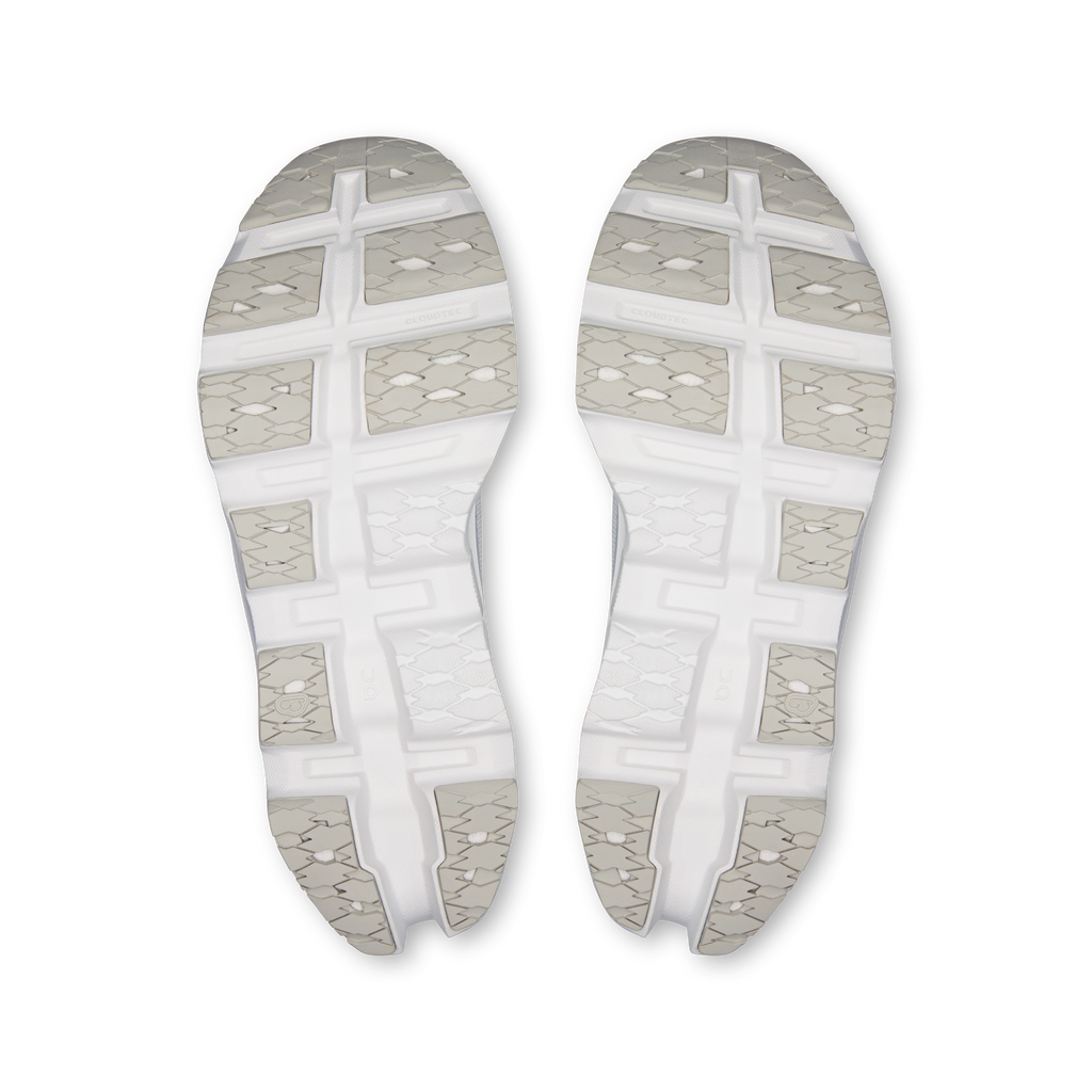 Pair of white sneaker outsoles with textured tread and gridded traction pods