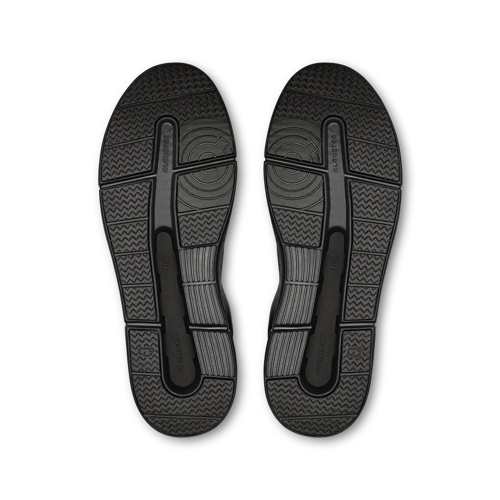 Black outsole view of low-top sneakers with textured traction pattern