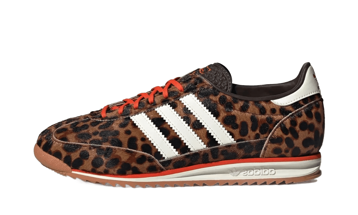Leopard print low-top sneakers with three white adidas stripes, orange laces