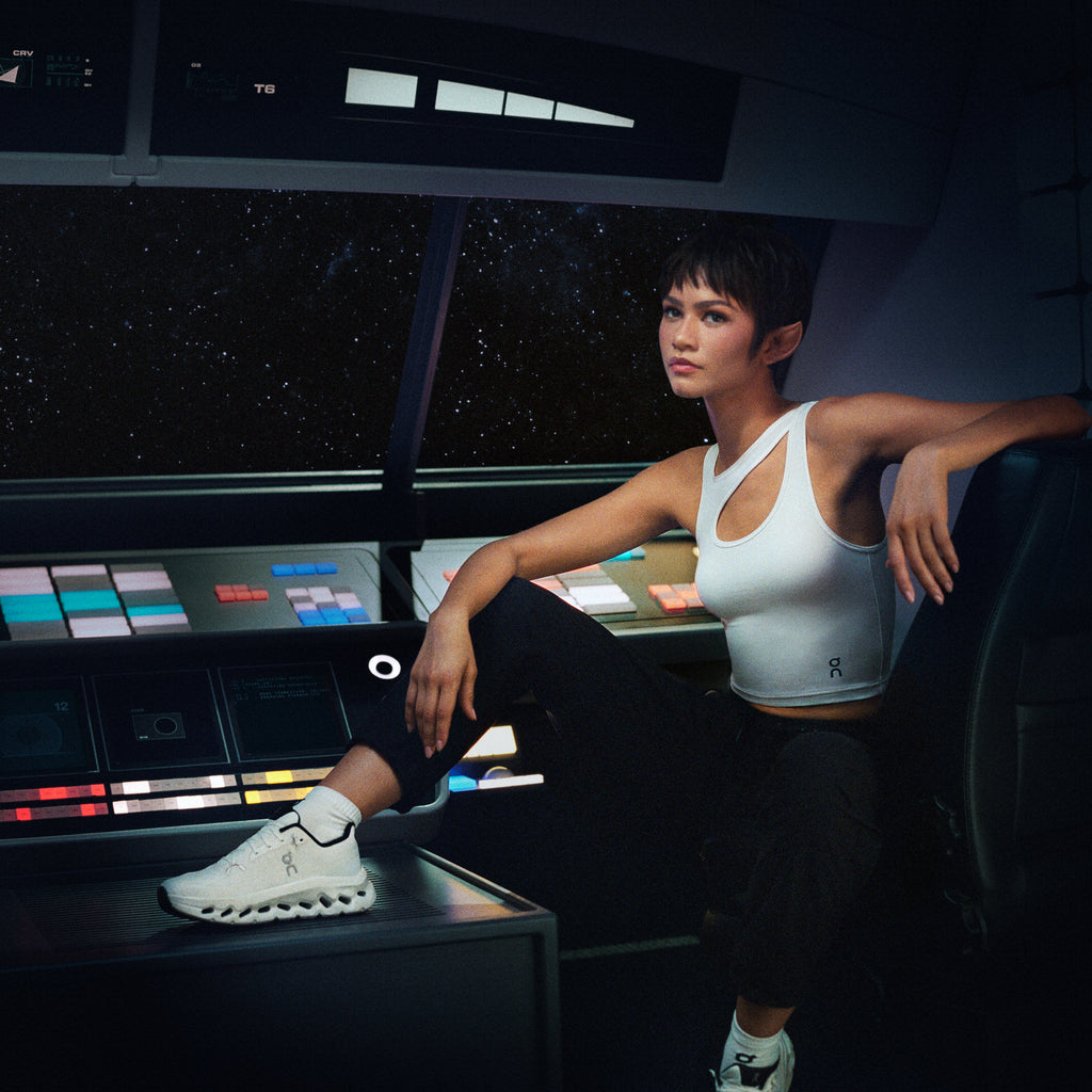 Women's running shoes on model, white upper with black heel lining