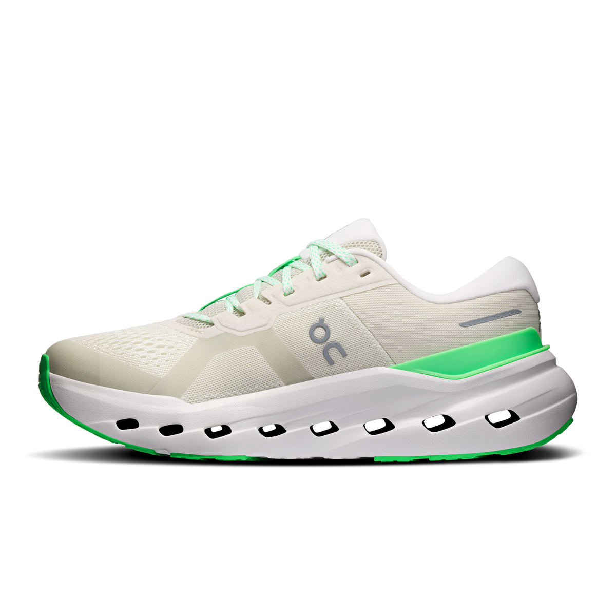 Women's running shoes in cream with green trim and black-and-white sole pods