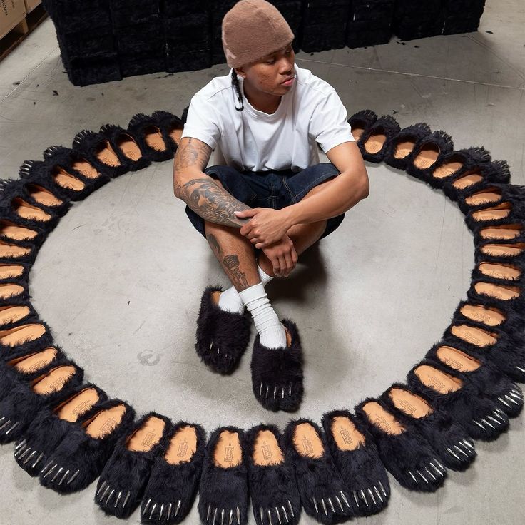 Black bear claw mules on feet, faux-fur slip-ons with metallic spike accents