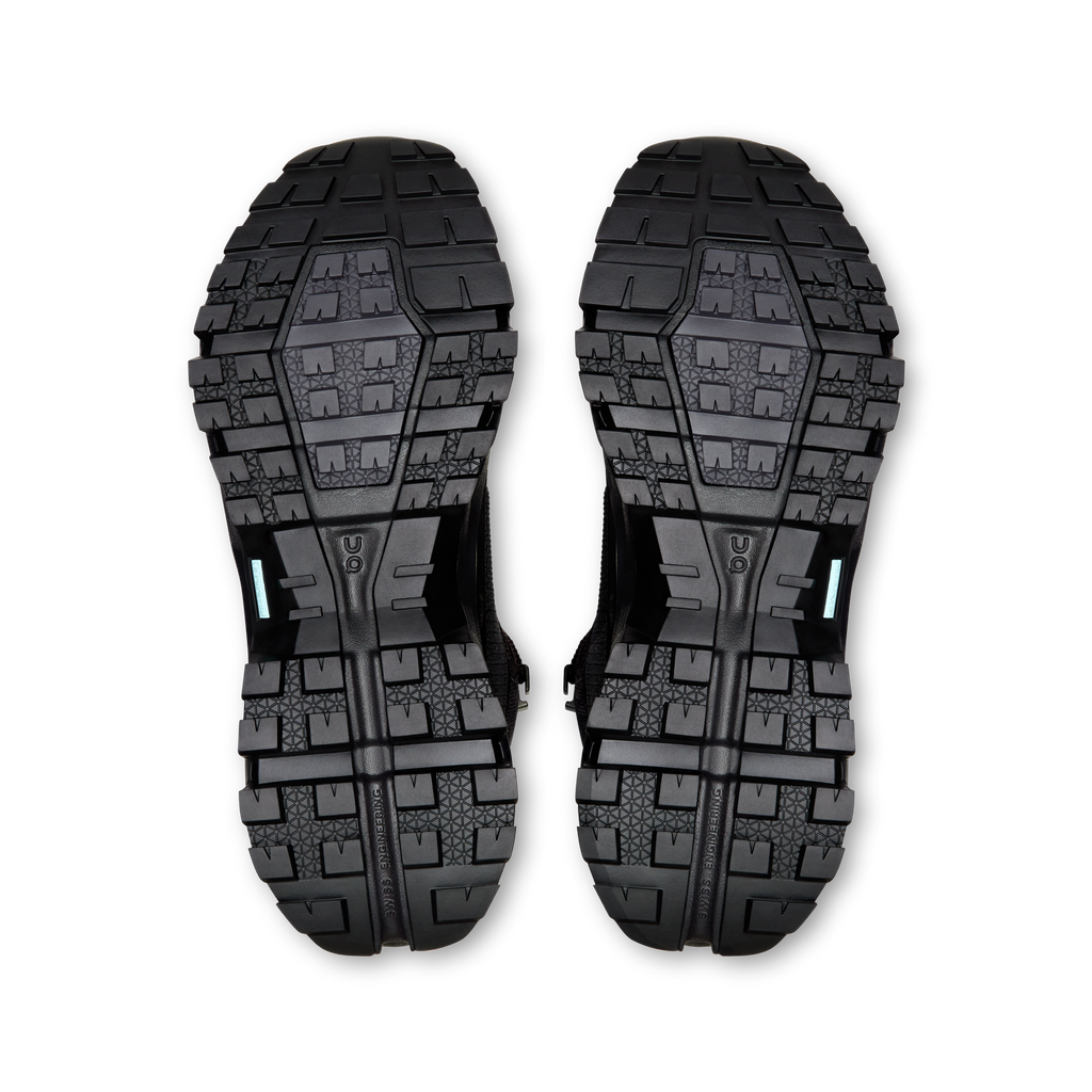 Pair of black shoe outsoles with blocky traction pattern and drainage channels
