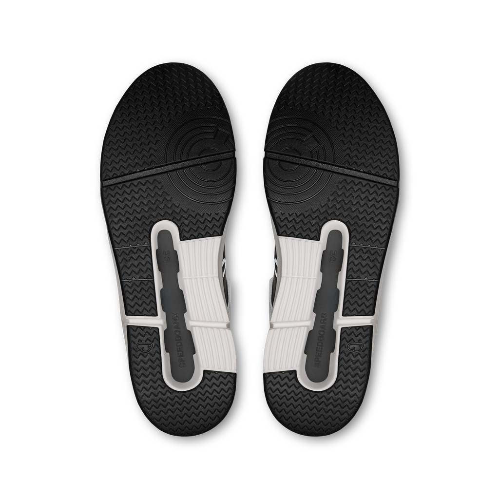 Pair of dark rubber sneaker outsoles with textured tread and molded traction pods