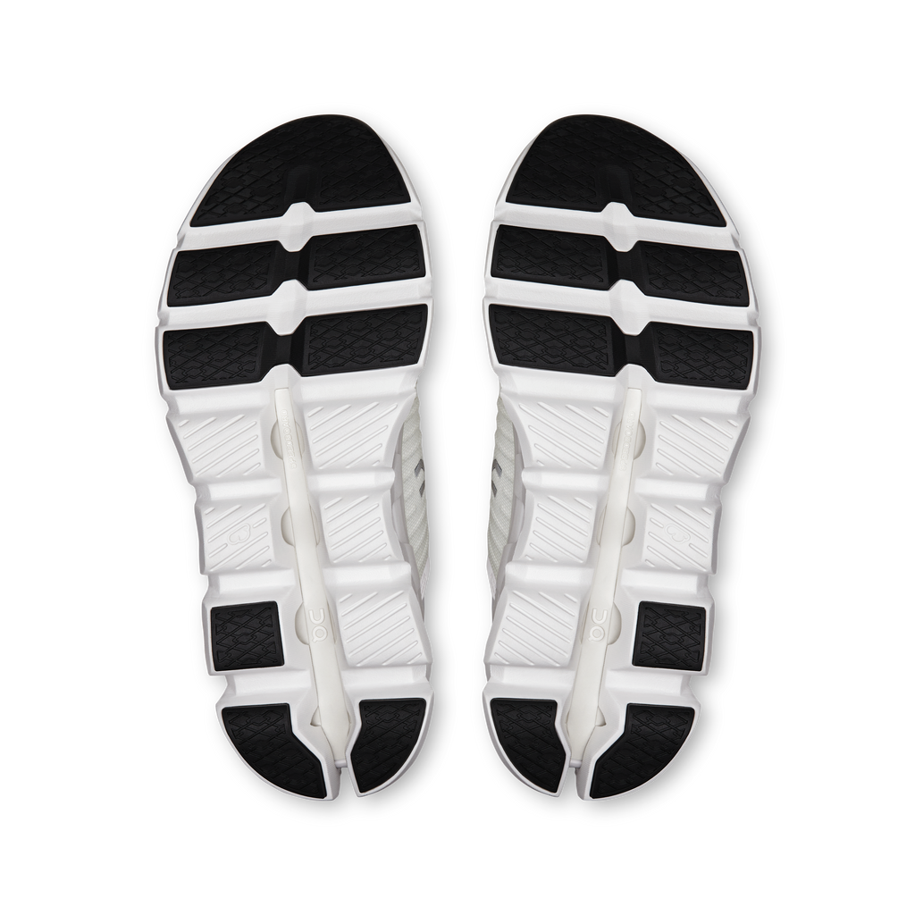 Pair of white shoe outsoles with black tread segments and CloudTec midsole