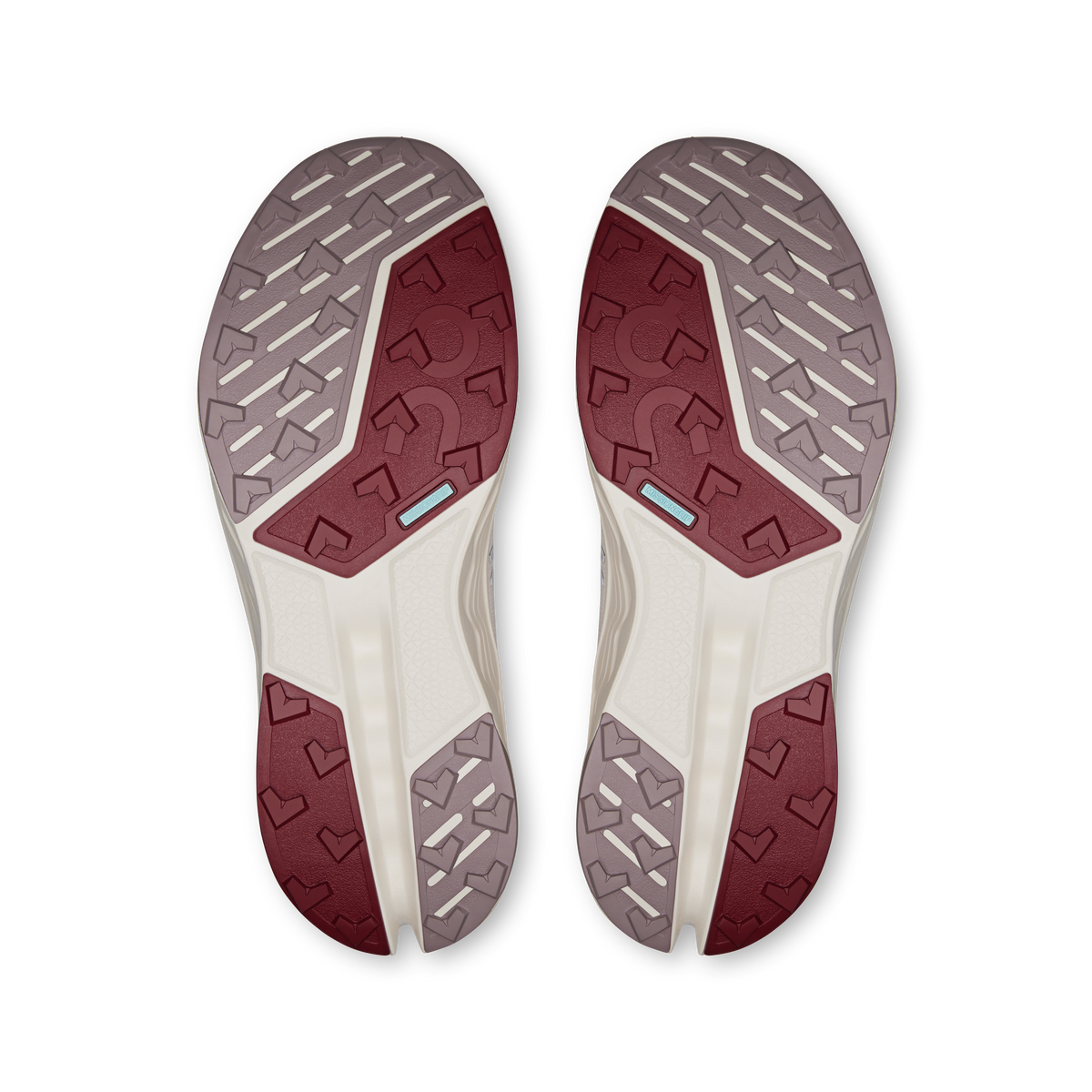 Pair of trail shoe outsoles with patterned rubber grips and burgundy traction panels