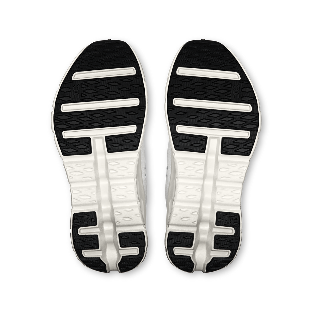Women's running shoe outsoles with tread and white cushioning pods
