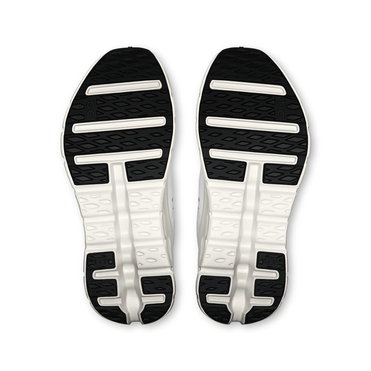 Women's running shoe outsoles with tread and white cushioning pods