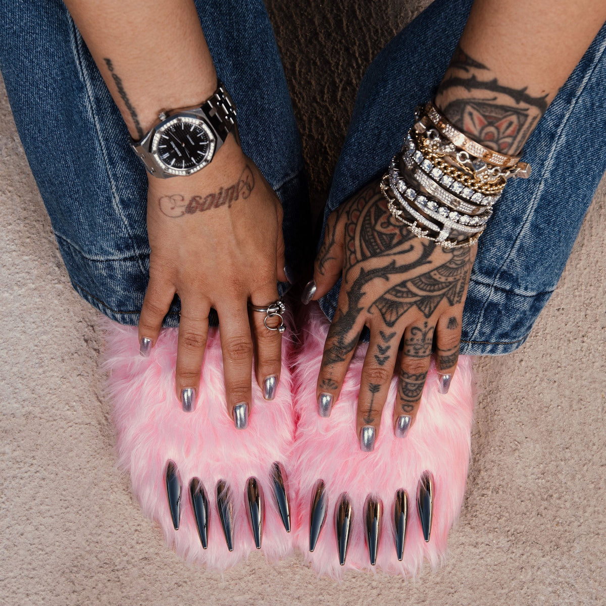 Pink faux-fur bear claw mules on bare feet, open claw design