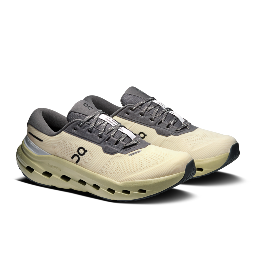 Pair of women's waterproof running shoes, pale yellow uppers with dark gray laces.