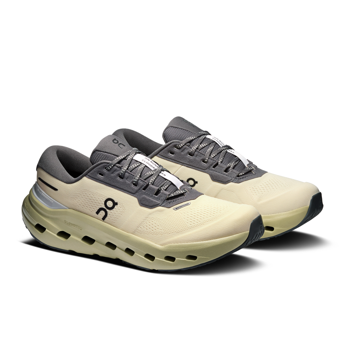 Pair of women's waterproof running shoes, pale yellow uppers with dark gray laces.