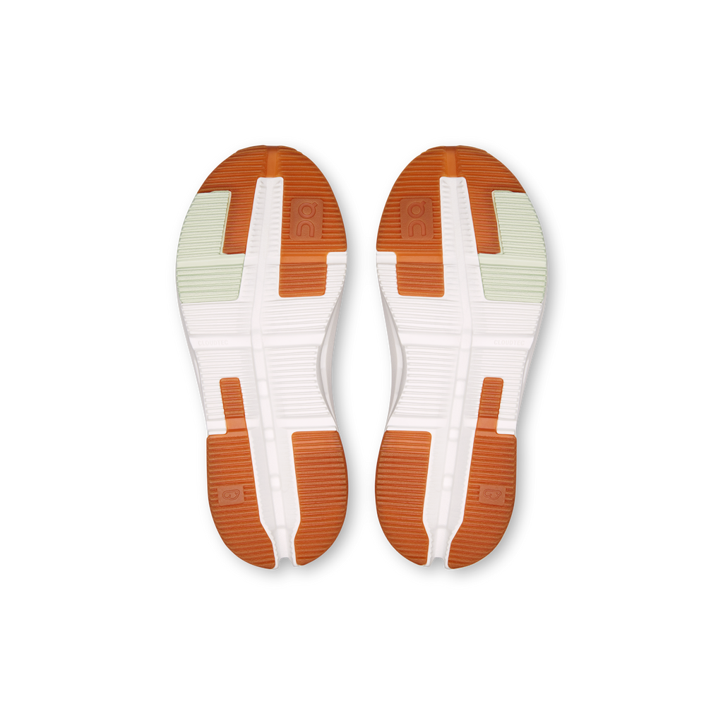 Kids' shoe outsole with orange traction pods and white tread pattern