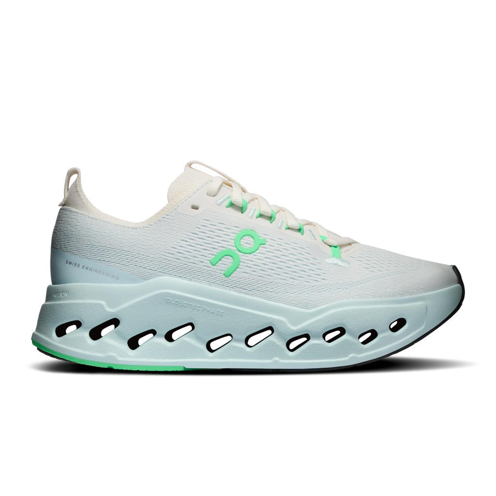 Women’s running shoes with ivory knit upper, green accents, and cloud-style pods