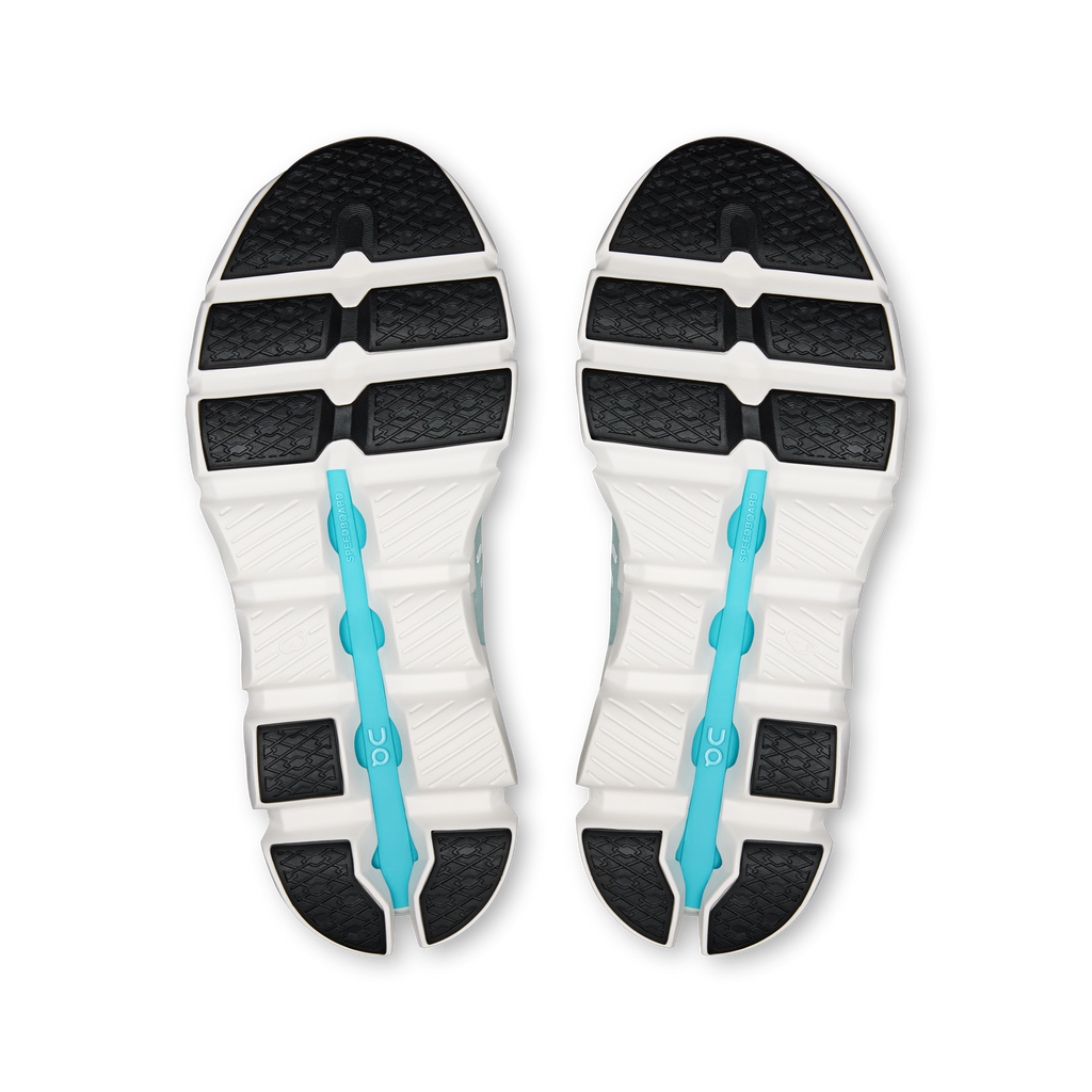 Shoe outsoles with black traction pattern, white midsole, and turquoise support fin