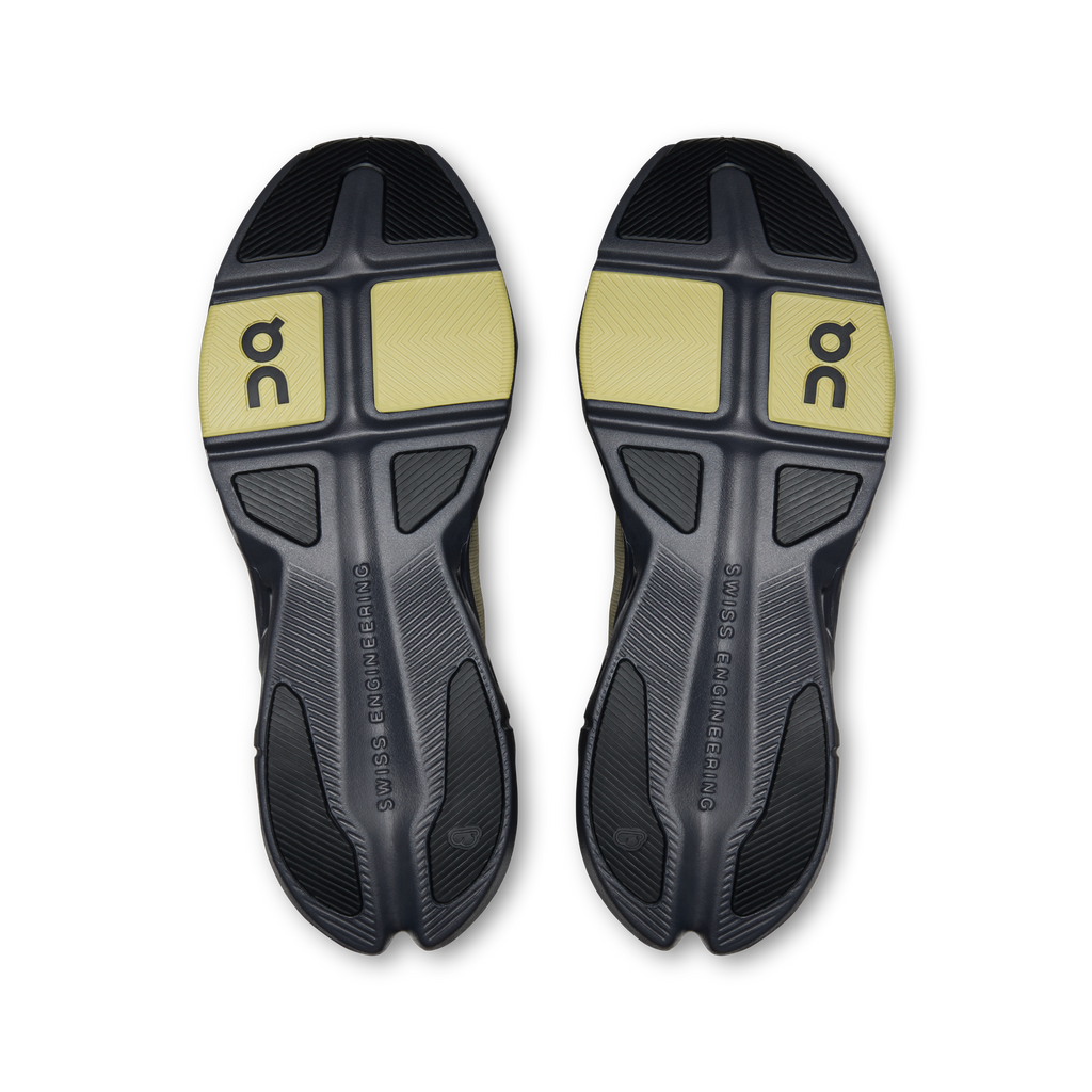 Shoe outsoles with dark rubber tread and yellow On logo panels, textured traction