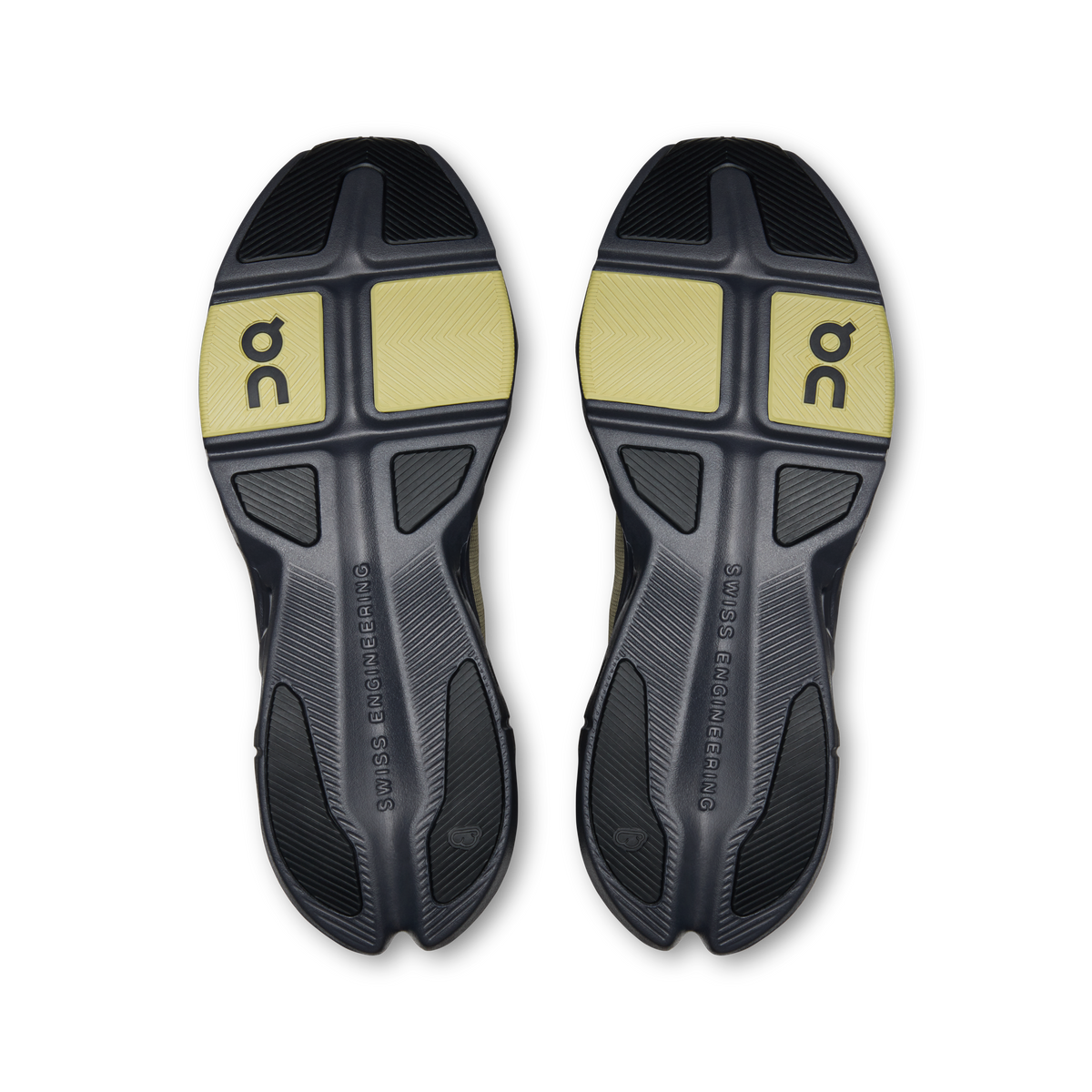 Shoe outsoles with dark rubber tread and yellow On logo panels, textured traction