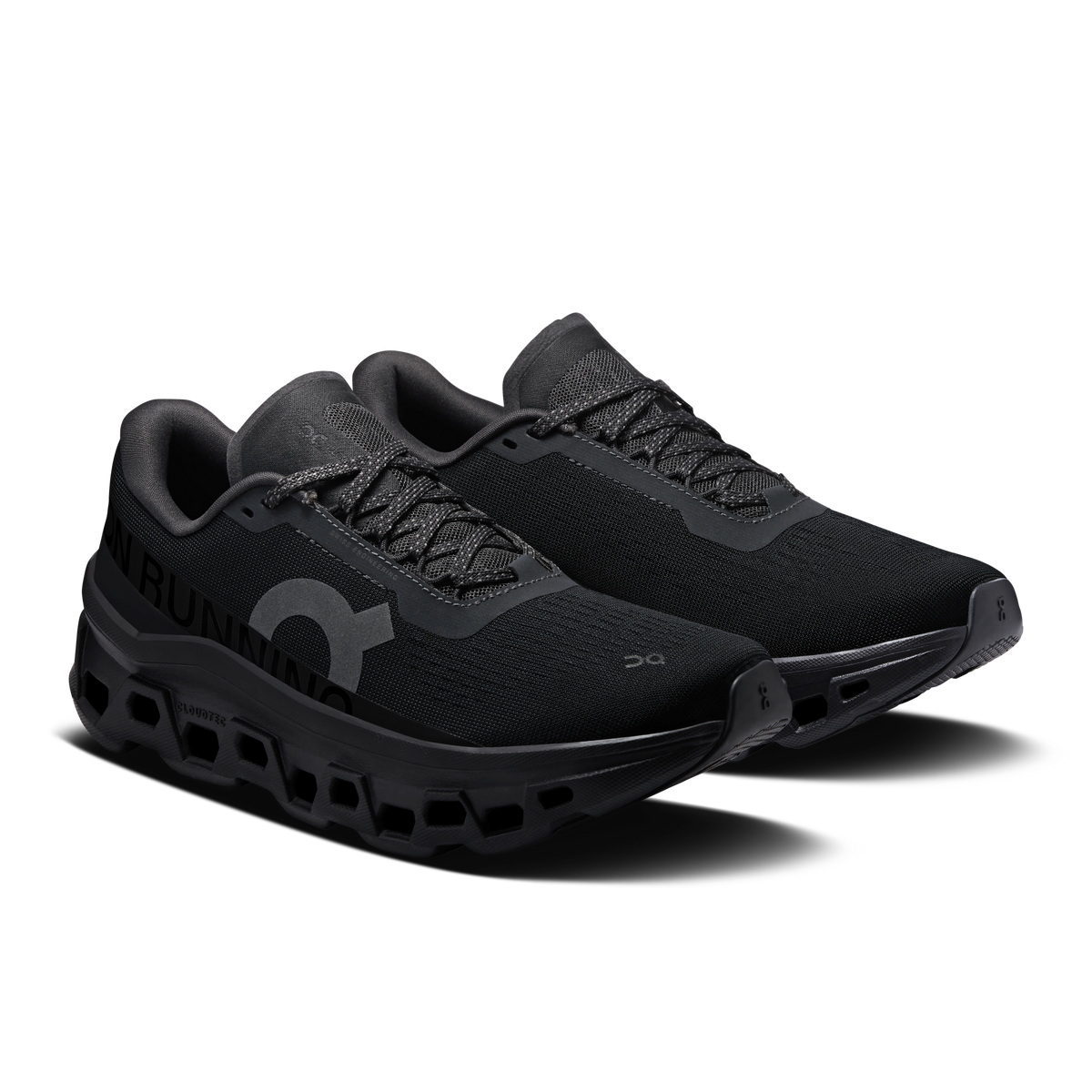 On Cloudmonster 1 women's black running shoes, angled side view with logo detail.