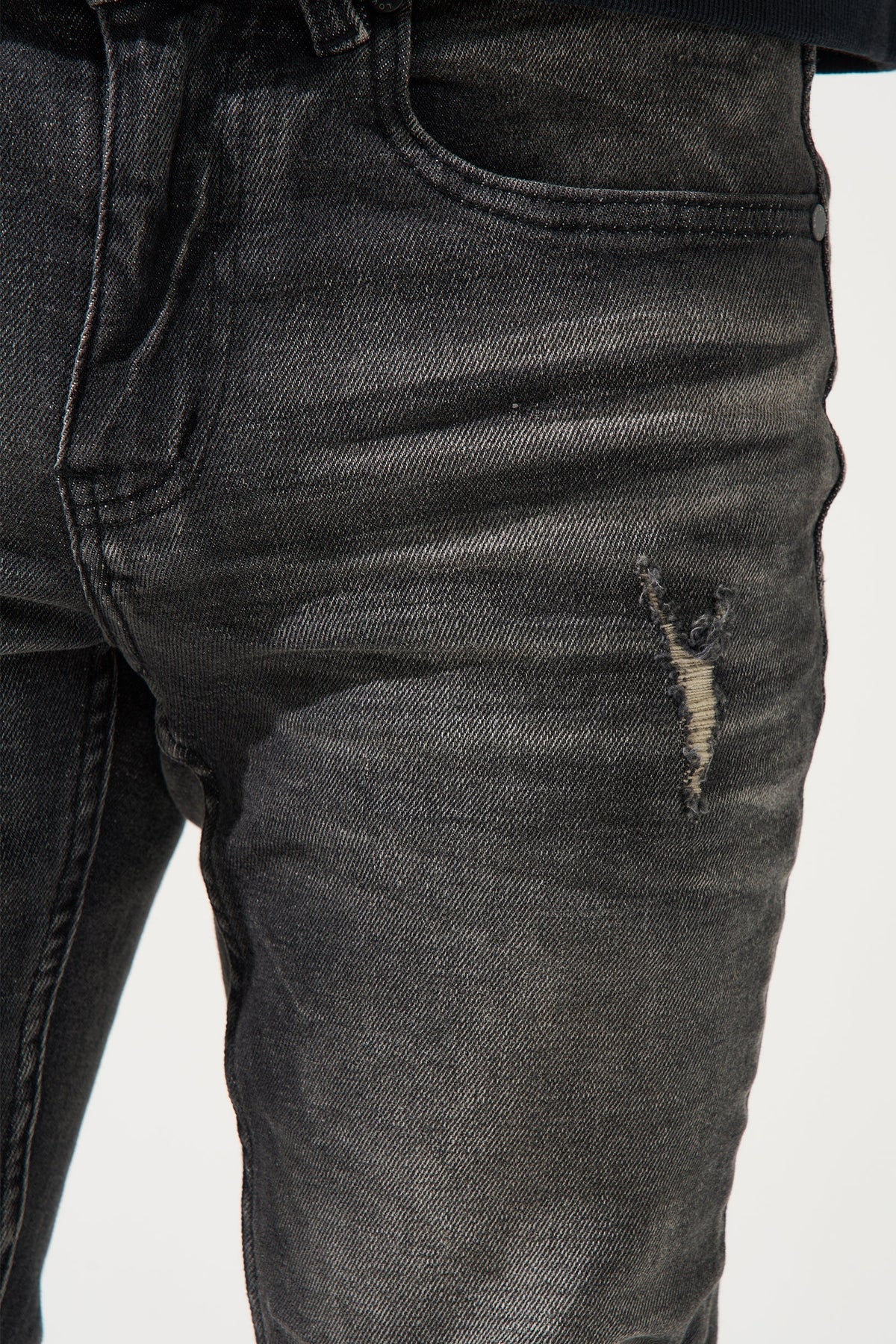 Men's dark gray washed jeans front with small distress on thigh
