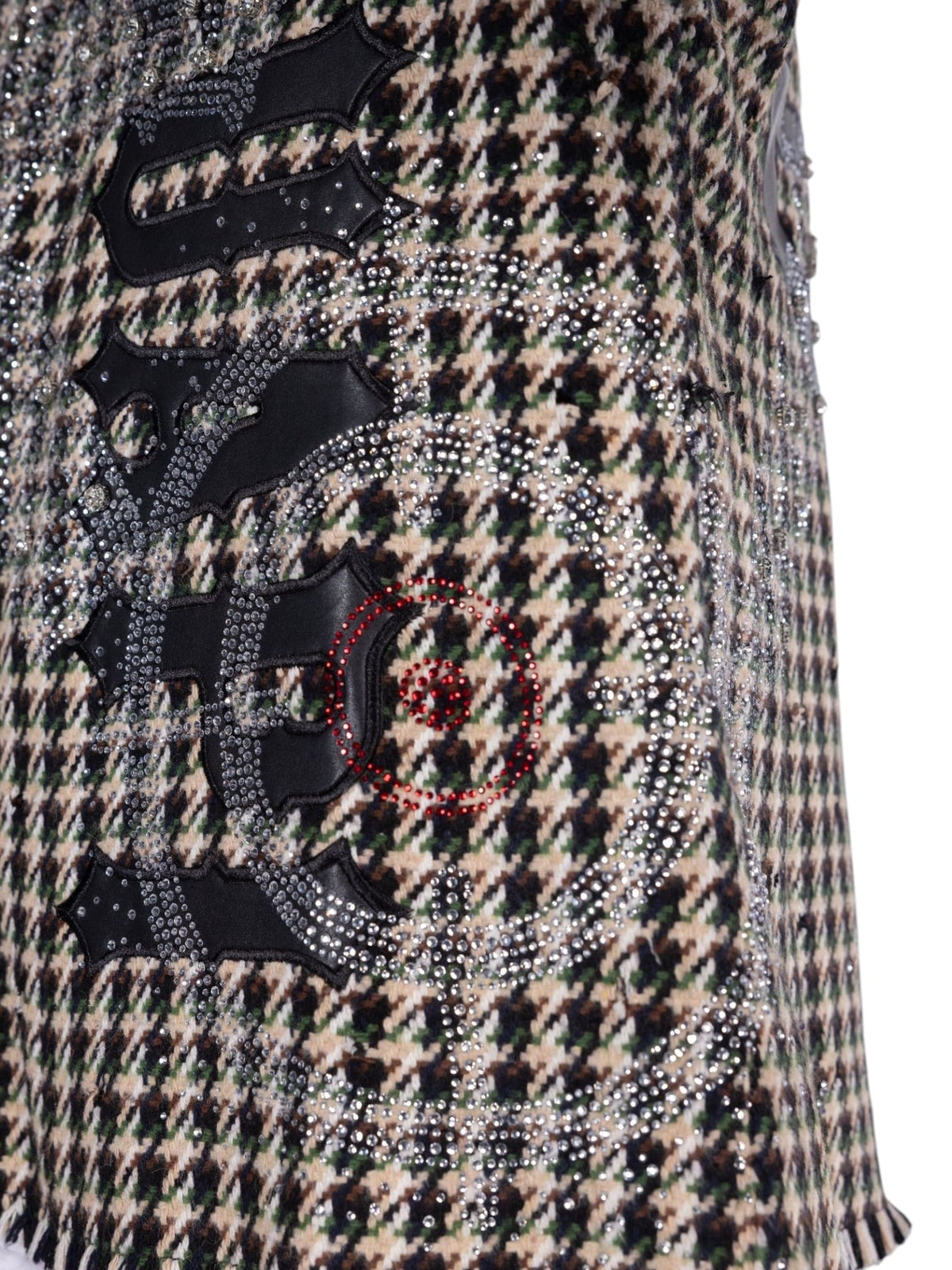 Close-up of rhinestone graphic patch with circular emblem and houndstooth fabric