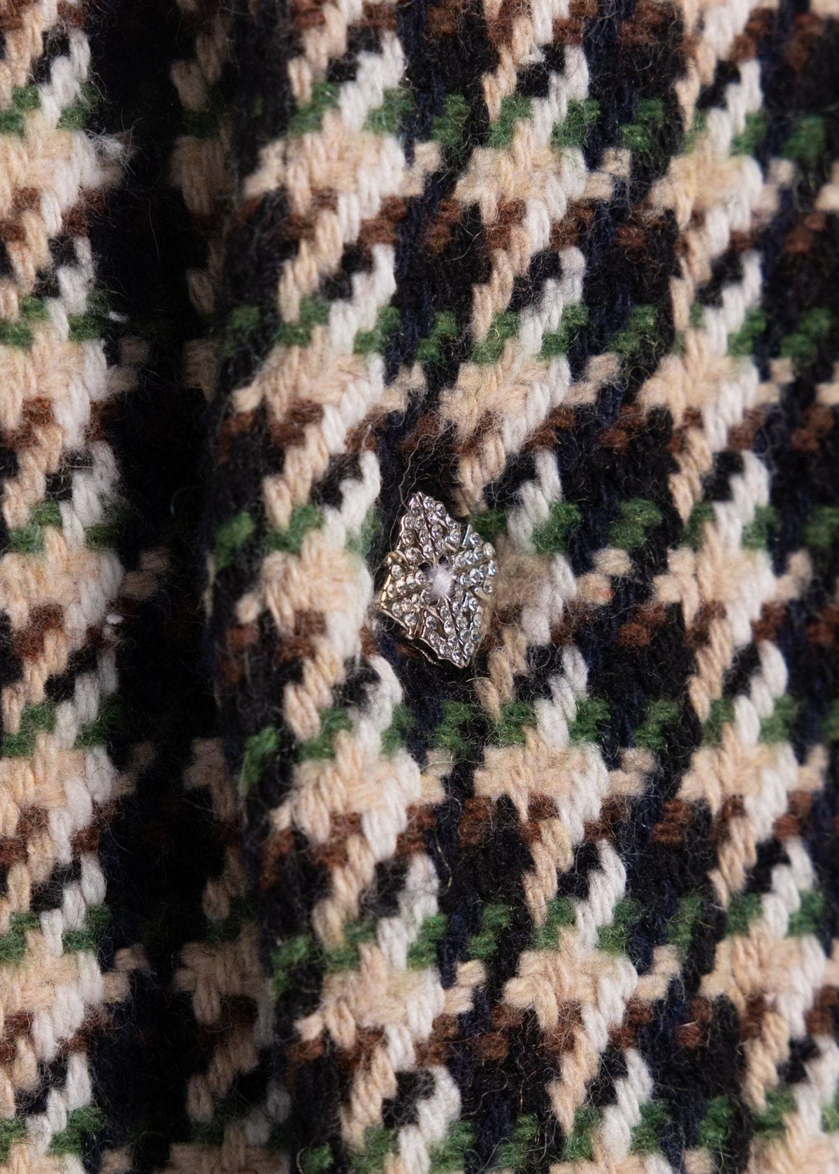Close-up of houndstooth fabric with rhinestone tip patch detail