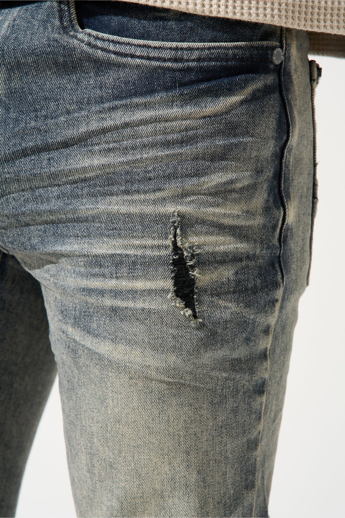 Men's gunmetal jeans with belt loop, rear pocket seam, and dark distressed patch