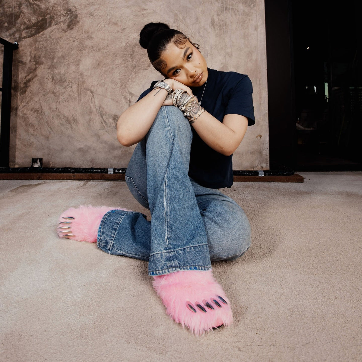Pink faux-fur bear claw mules with open toe claws under jeans