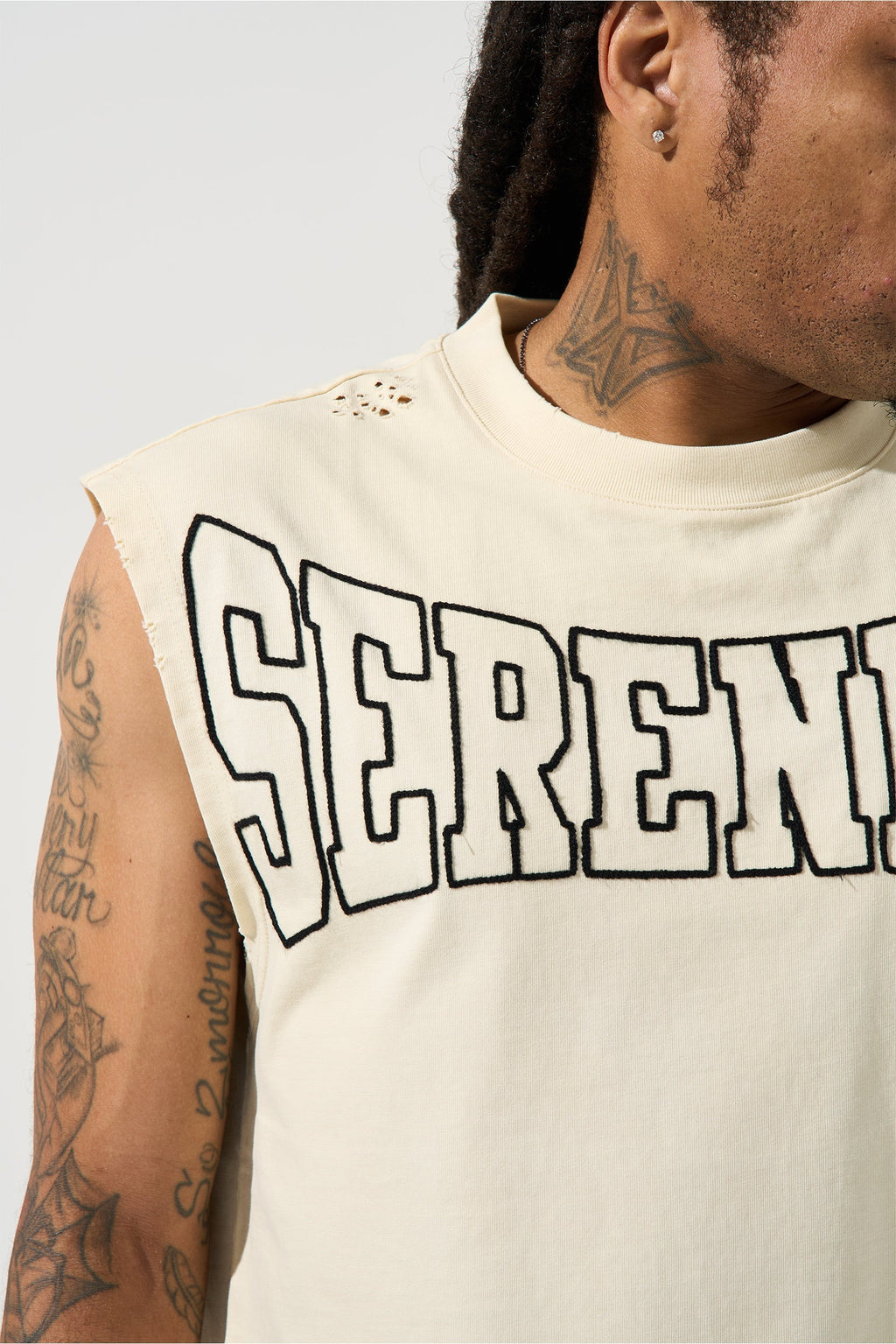 Ivory sleeveless tank with large SERENED logo text on chest