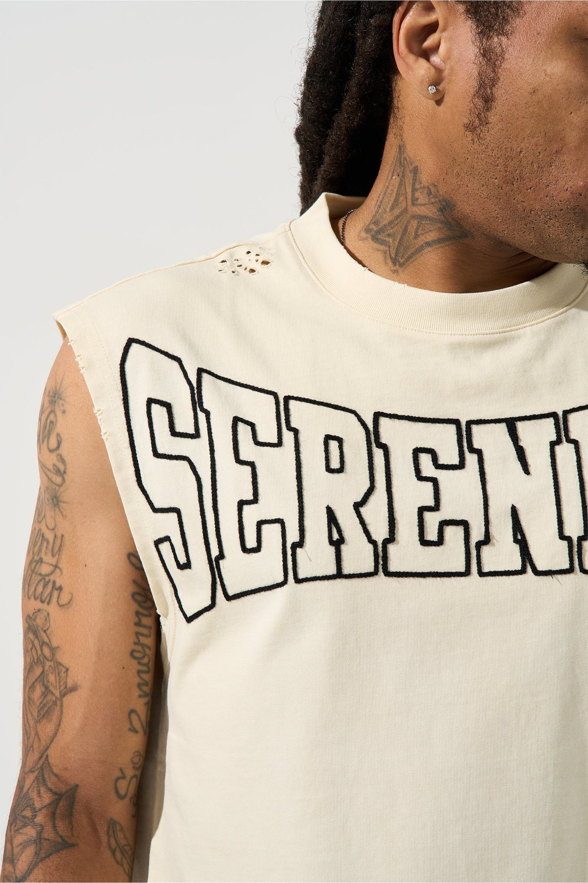 Ivory sleeveless tank with large SERENED logo text on chest