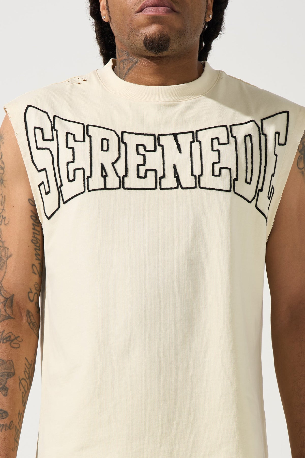 Ivory tank top with oversized SERENED logo graphic across chest